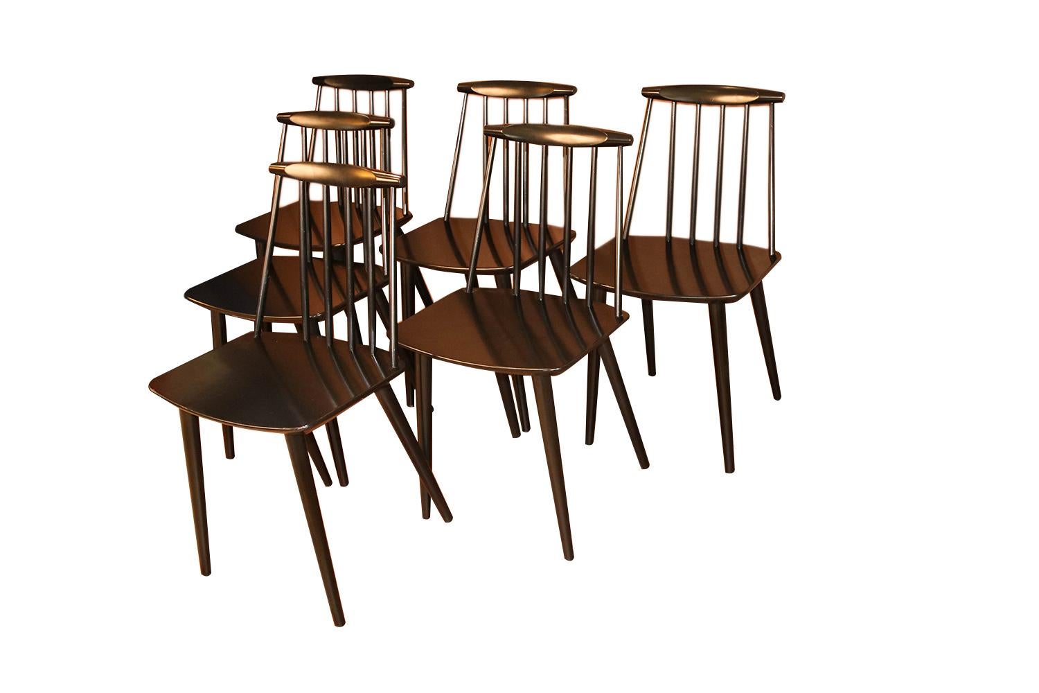 Exceptional set of six original, Spindle Back, model J77 Chairs by Folke Palsson for FDB Mobler, Denmark, circa 1970s. They are of solid wood construction featuring a concave serpentine crest rail above six turned spindles. The scooped seat is