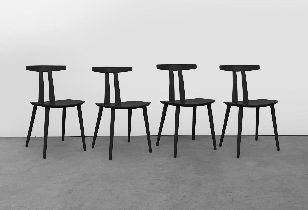 This set of four black lacquered dining chairs were designed by Folke Pålsson for FDB Møbler, Denmark. They feature wide curved geometric seats, tapered legs and a unique back support aptly giving these chairs the name 