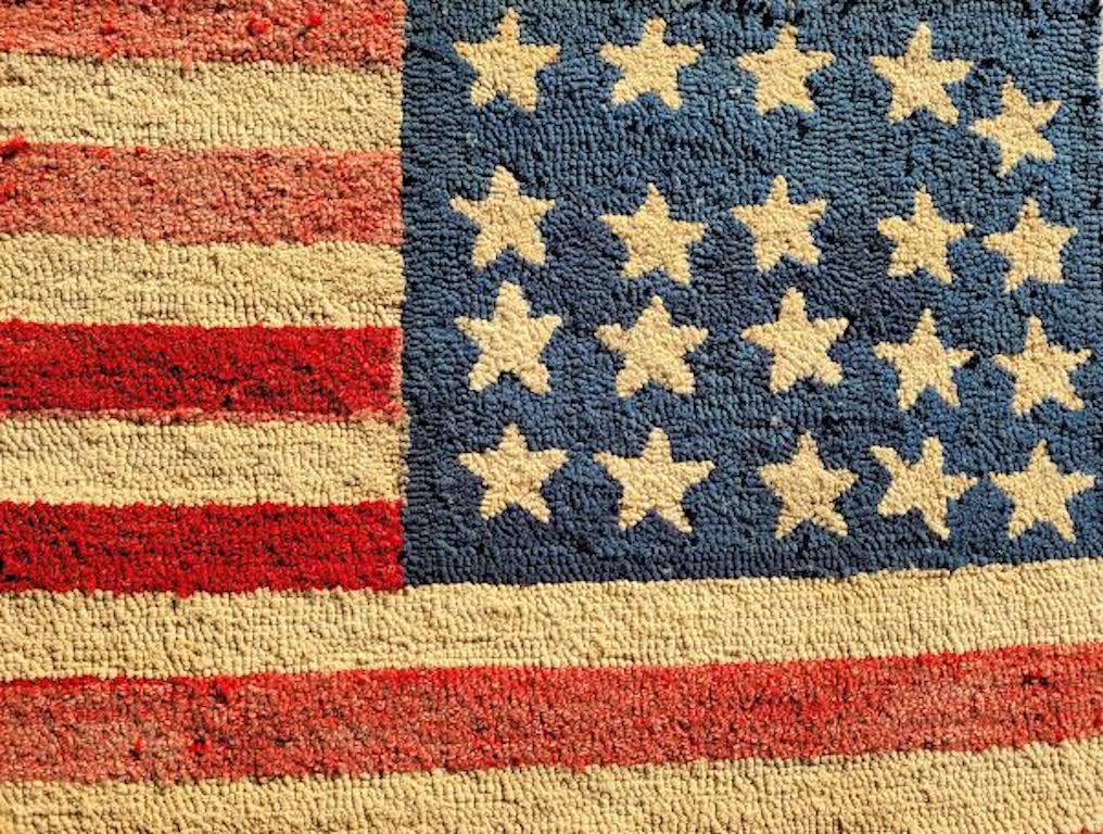 This very folky reverse 20 stars hand hooked American Flag rug is on a stretcher frame.It is most unusual due to the reverse of the American flag and twenty stars contained.Minor fade throughout consistent with age and use. Minor fabric loss due to