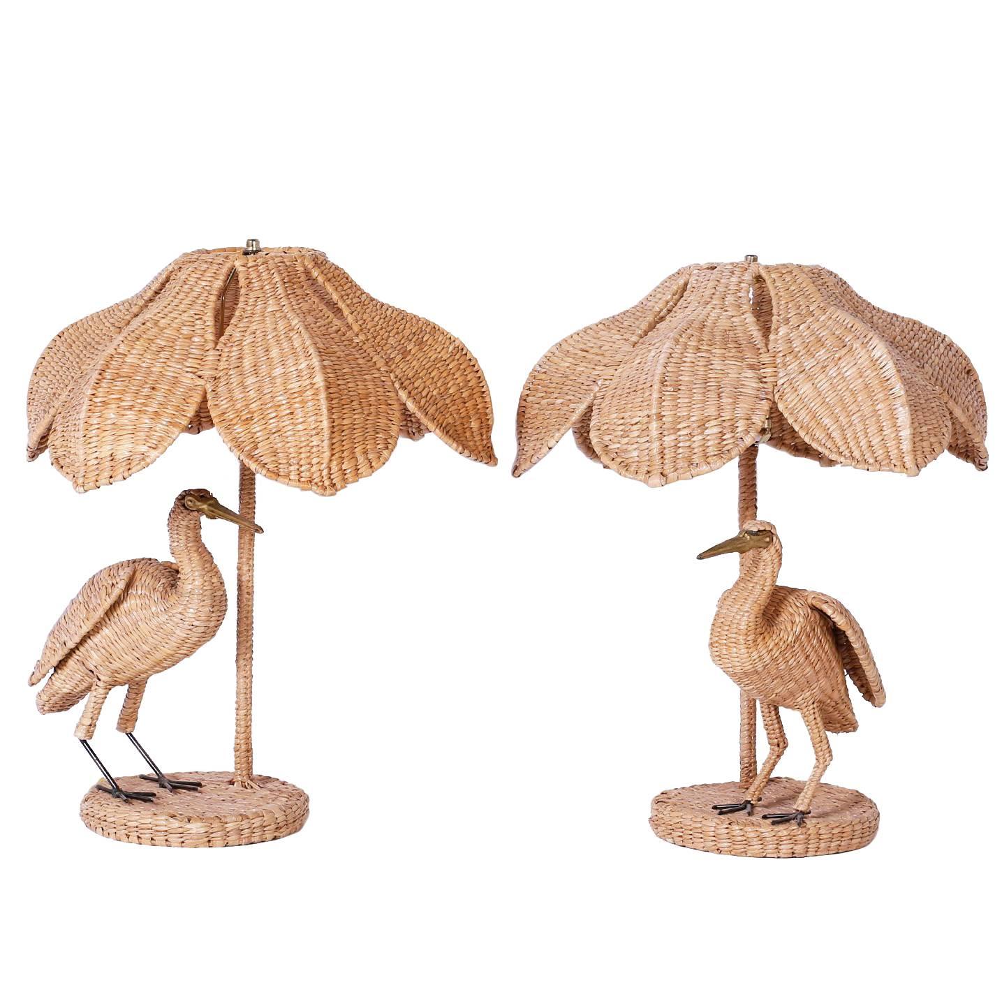 Folky and fun pair of wicker or reed egret table lamps. These birds have a brass face and beak and your choice of wicker or linen shades. Signed Mario Torres, with a brass label on the bottom.
 