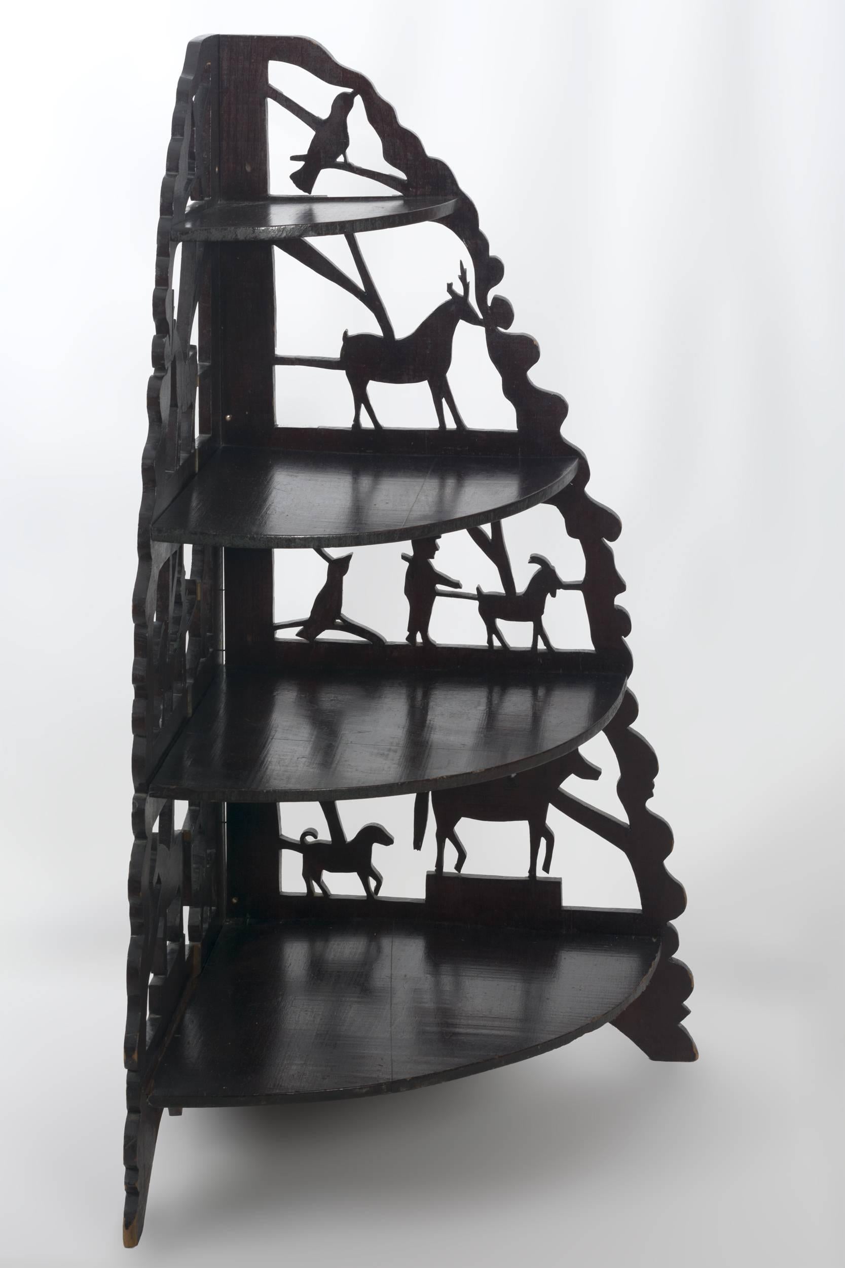 Four tiered with a pierced back displaying birds, 
deer, goats, horses and a farmer. The sides and 
feet are scalloped, made of walnut
American, circa 1930
Measures: 42” x 28” x 18 ½”.
 