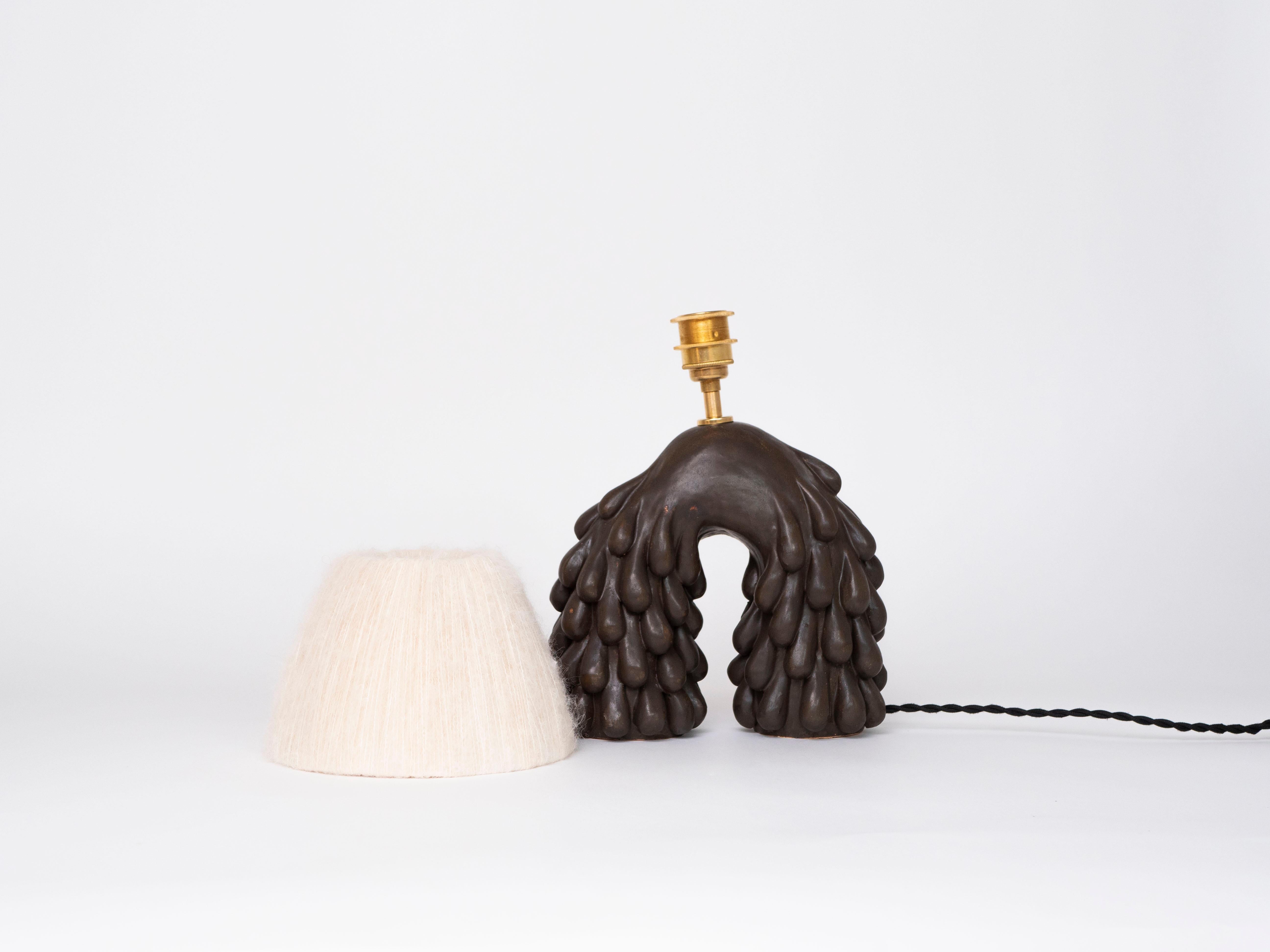 Satin brown/black glaze on a hand-built earthenware form. Paired with a cream alpaca silk lampshade. 
The form is covered in a drip texture, which creates a contrasting appearance to the soft lampshade. 

This lamp will create a statement look in