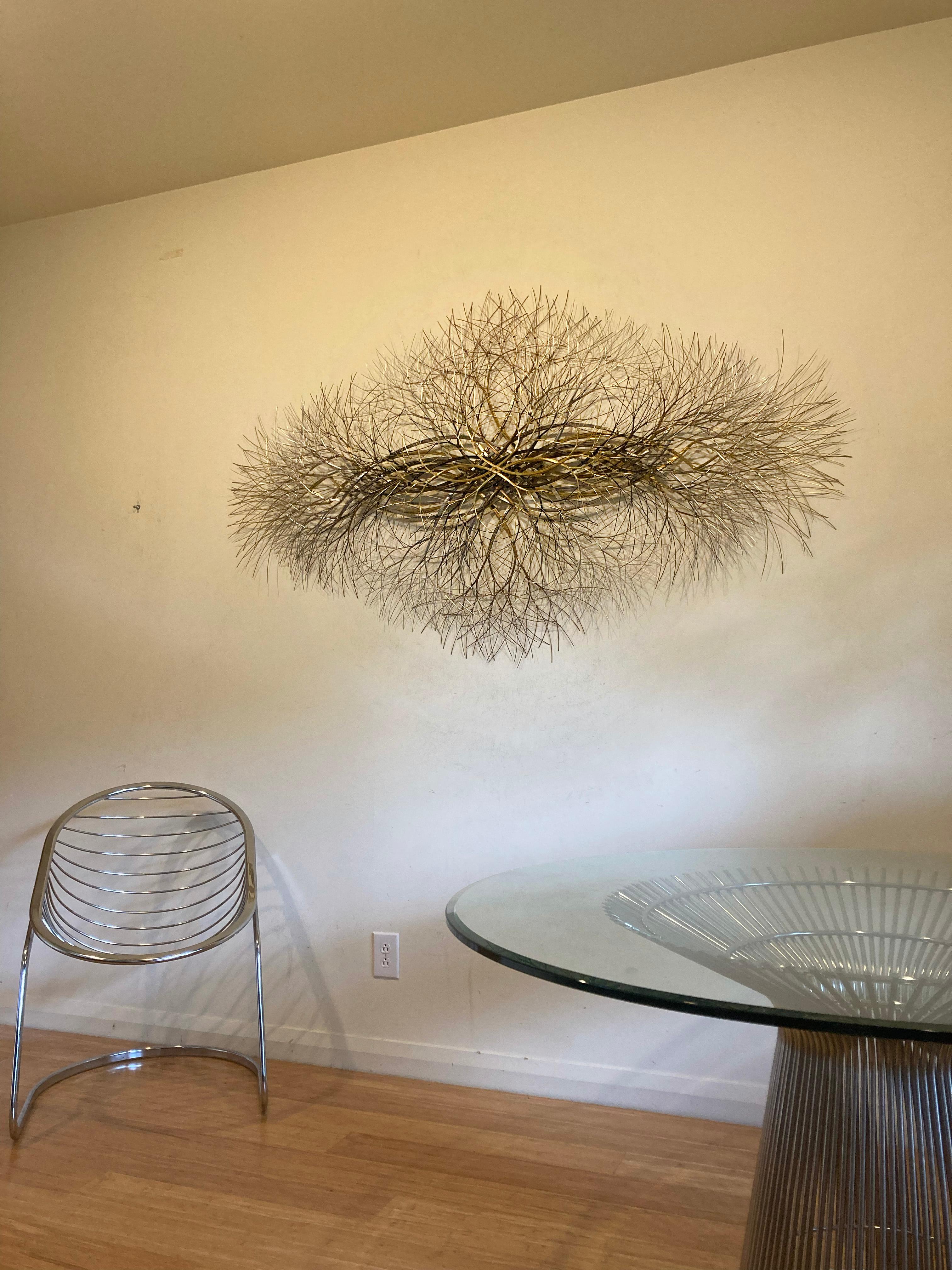 Bronze, brass, and stainless steel wire. 

This abstract sculpture is suitable for an entryway or perhaps a yoga studio or spiritual space. The artist uses a modern aesthetic reminiscent of trees, electricity, and light to create sculptures of