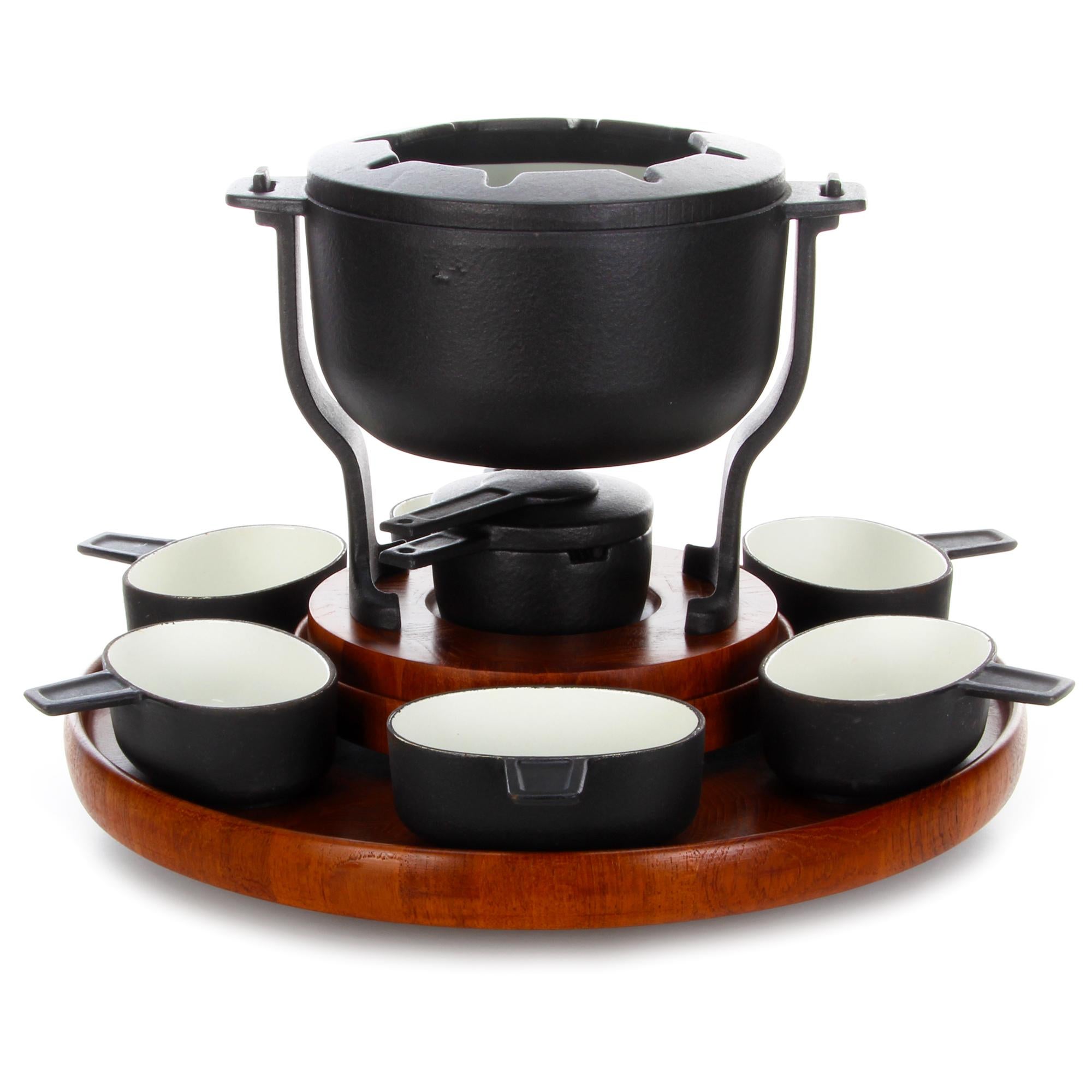 Fondue set, designed by Flemming Digsmed (presumed) in the 1960s, beautiful complete teak and cast iron fondue set in very good vintage condition.

A very stylish fondue set comprised of a teak Lazy Susan/turntable with a static center, where a