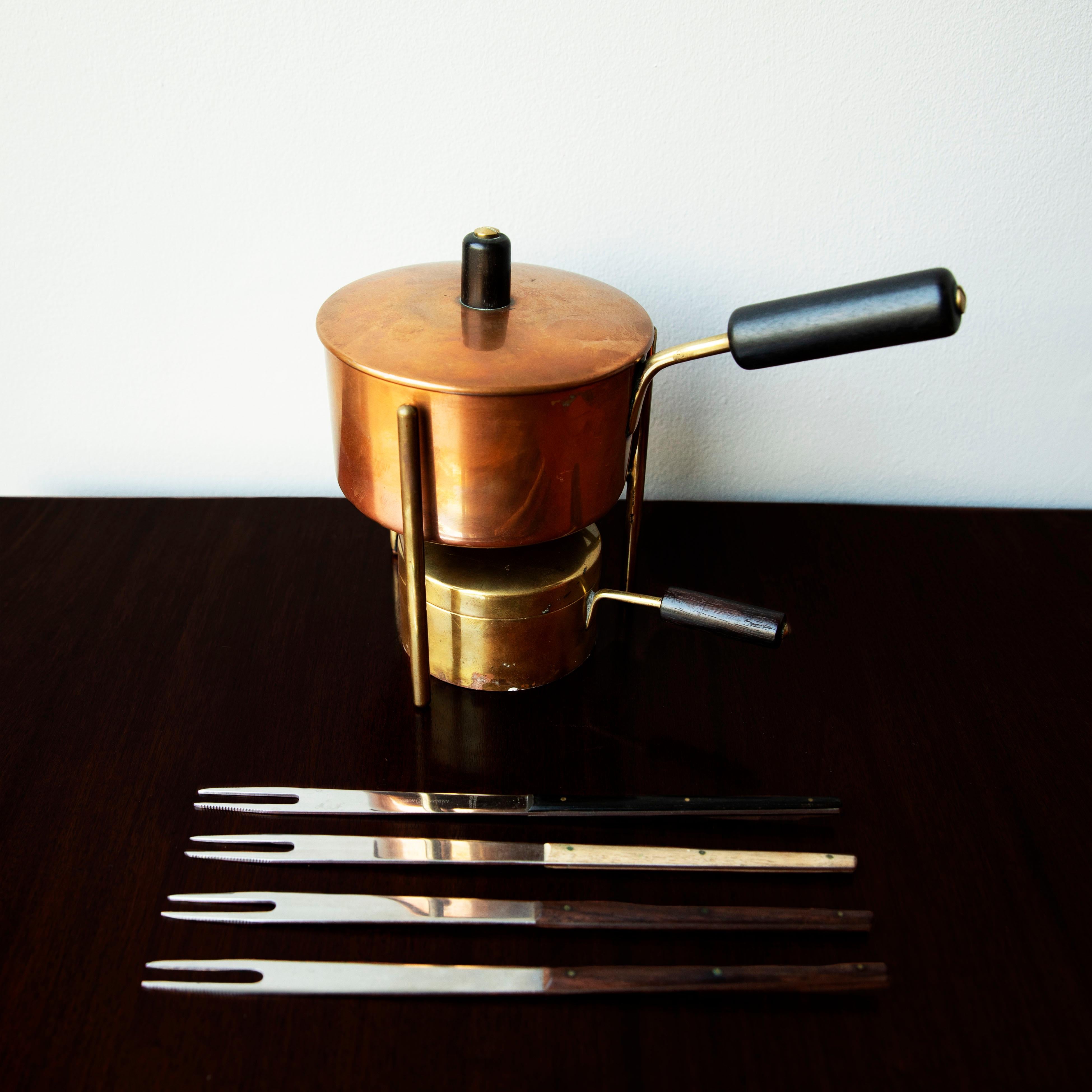 Vintage fondue pot and burner by Carl Auböck II, Vienna, circa 1950.
The pot and its lid are made out of spun tinned copper, while the burner is spun brass. The pot, its lid and the burner, all have brass handles with ebony grips.
The sculptural