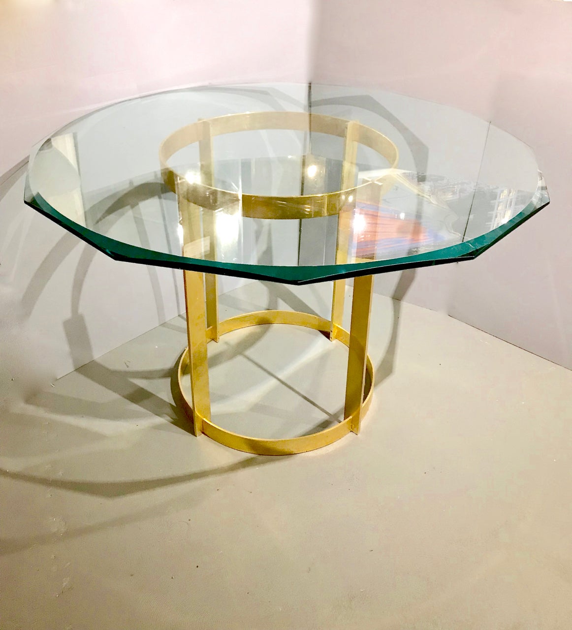 This is a stunning gilt bronze and glass center or dining table attributed to/style of Fontana Arte that dates to circa 1980s. The minimal linear design of the gilt bronze base allows the table to integrate perfectly into a period design concept, as