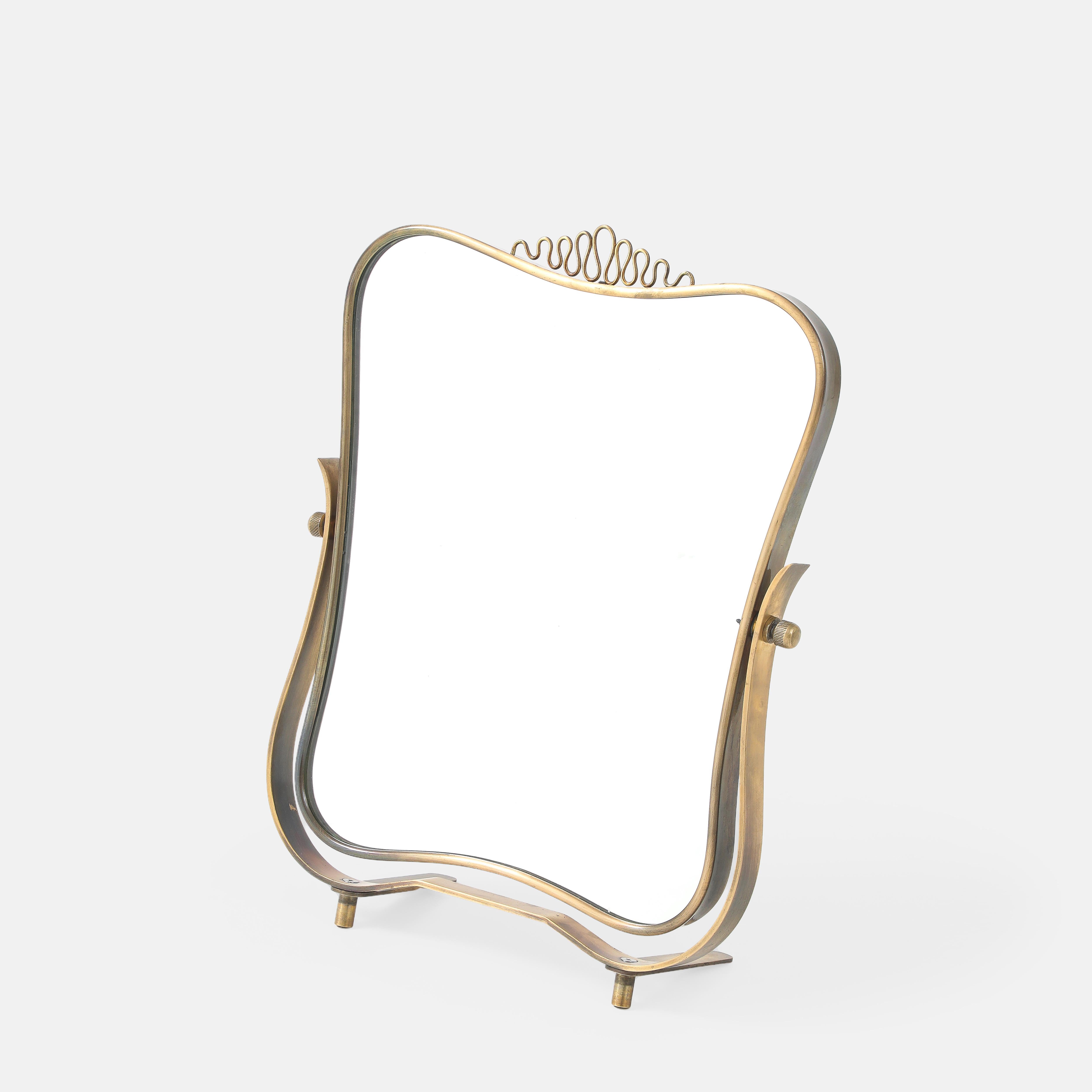 Luigi Fontana para Fontana Arte Raro y exquisito espejo de tocador o de sobremesa regulable, compuesto por un marco de latón de formas curvilíneas con decoración de volutas de latón en la parte superior central, que descansa sobre un soporte curvo
