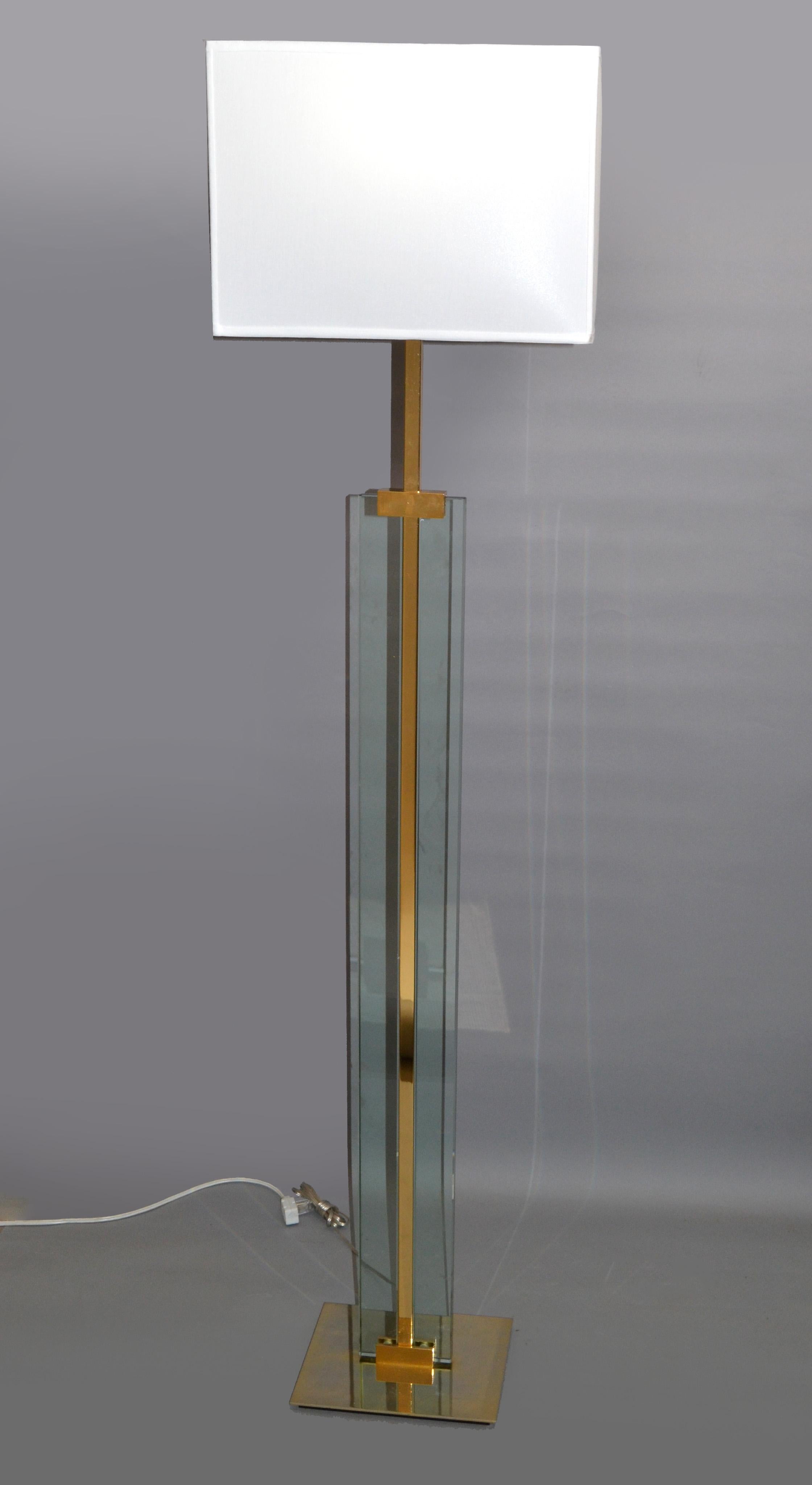 Original 1960s Fontana Arte Art glass floor lamp with polished brass base, stem and neck.
Heavy rectangular block of tinted beveled glass fastened by a polished brass shaft and comes with custom made rectangle fabric shade.
US rewiring and takes 1