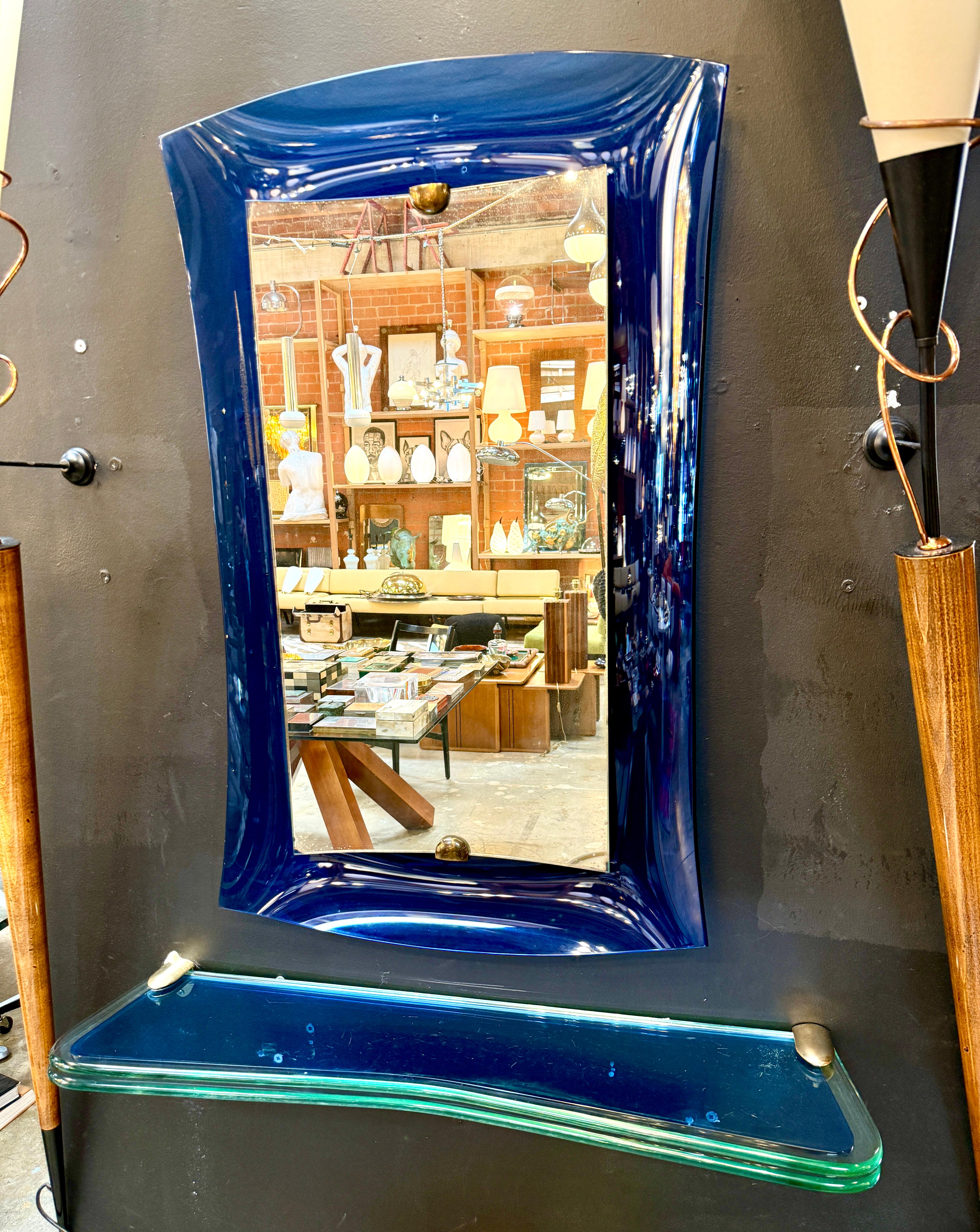 This is a striking mirror with console designed by Fontana Arte, dating from 1970s Italy. The design showcases the bold elegance typical of the era and the craftsmanship that Fontana Arte is known for.

Description:

Mirror Frame: The mirror is set