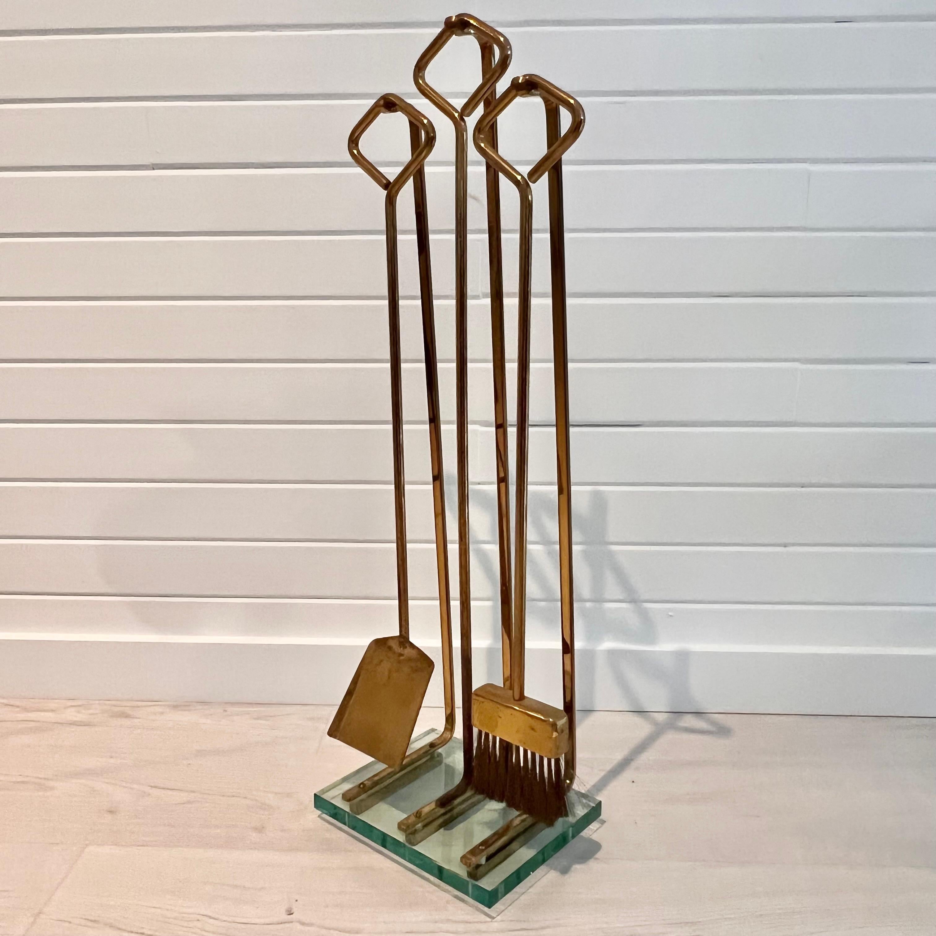 Elegant mid-century modern fireplace tool set by Fontana Arte, circa 1970’s. Set includes shovel, poker and broom. Original brass bristles on broom. The set is executed in brass, with each handle fitted with a diamond-shaped, bent-brass handle,