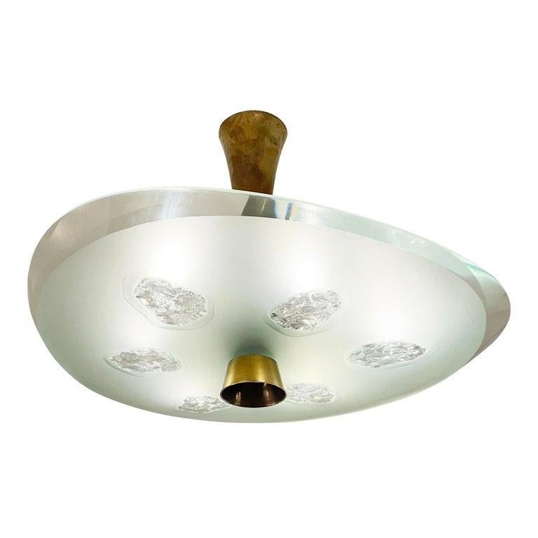 Fontana Arte ceiling light model 1748 designed by Max Ingrand in the 1950s. Features a beautiful thick glass shade with beveled edges which has been chiseled in six irregular areas. Holds six candelabra bulbs. Two available.

Condition: Excellent