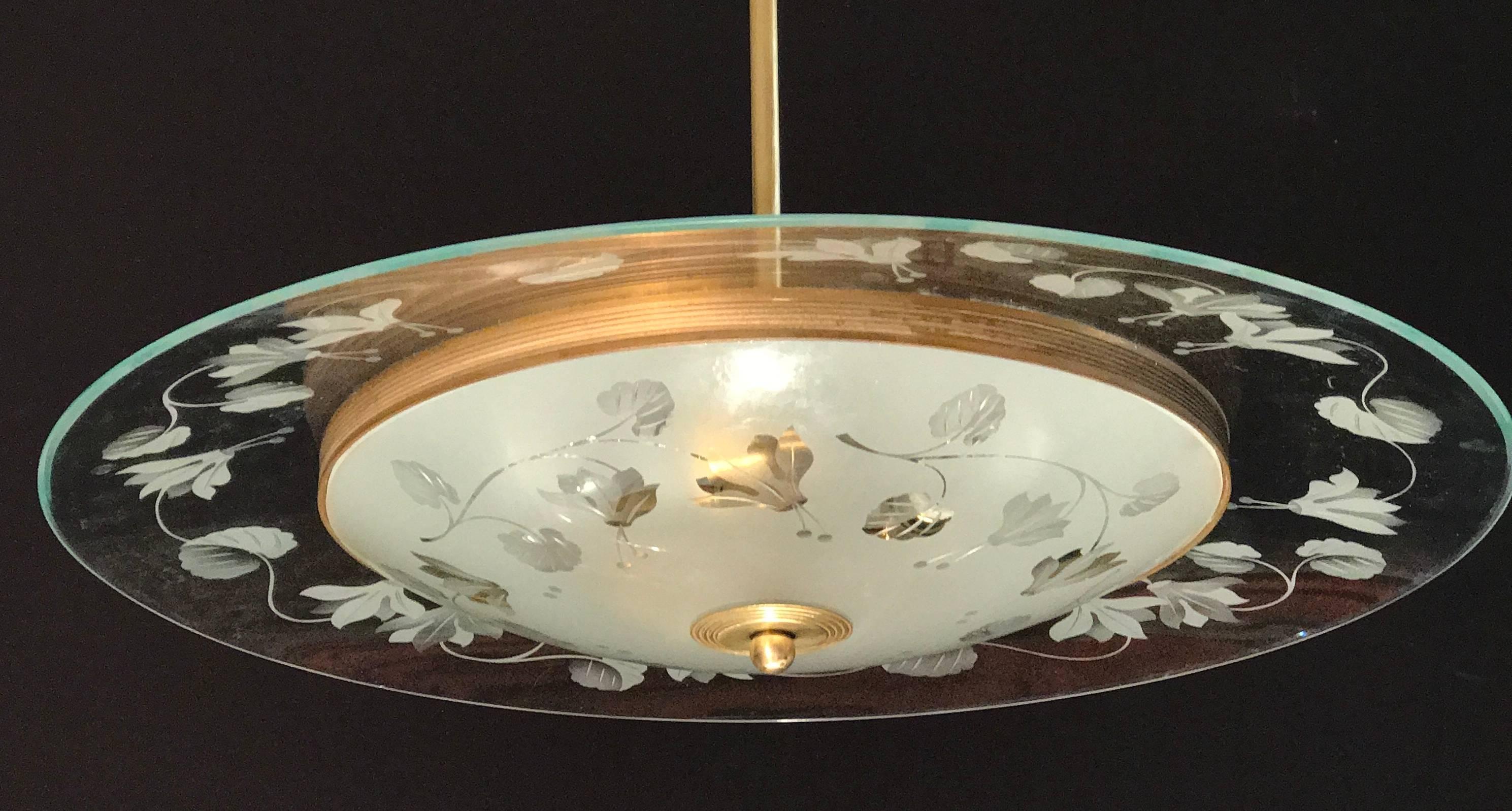 Finely hand chiseled glass with hibiscus motifs with brass rim in excellent vintage condition. The disc covering three E 14 light bulbs. This piece is from Fontana Arte designed by Pietro Chiesa one of the greatest Italian deco designer.