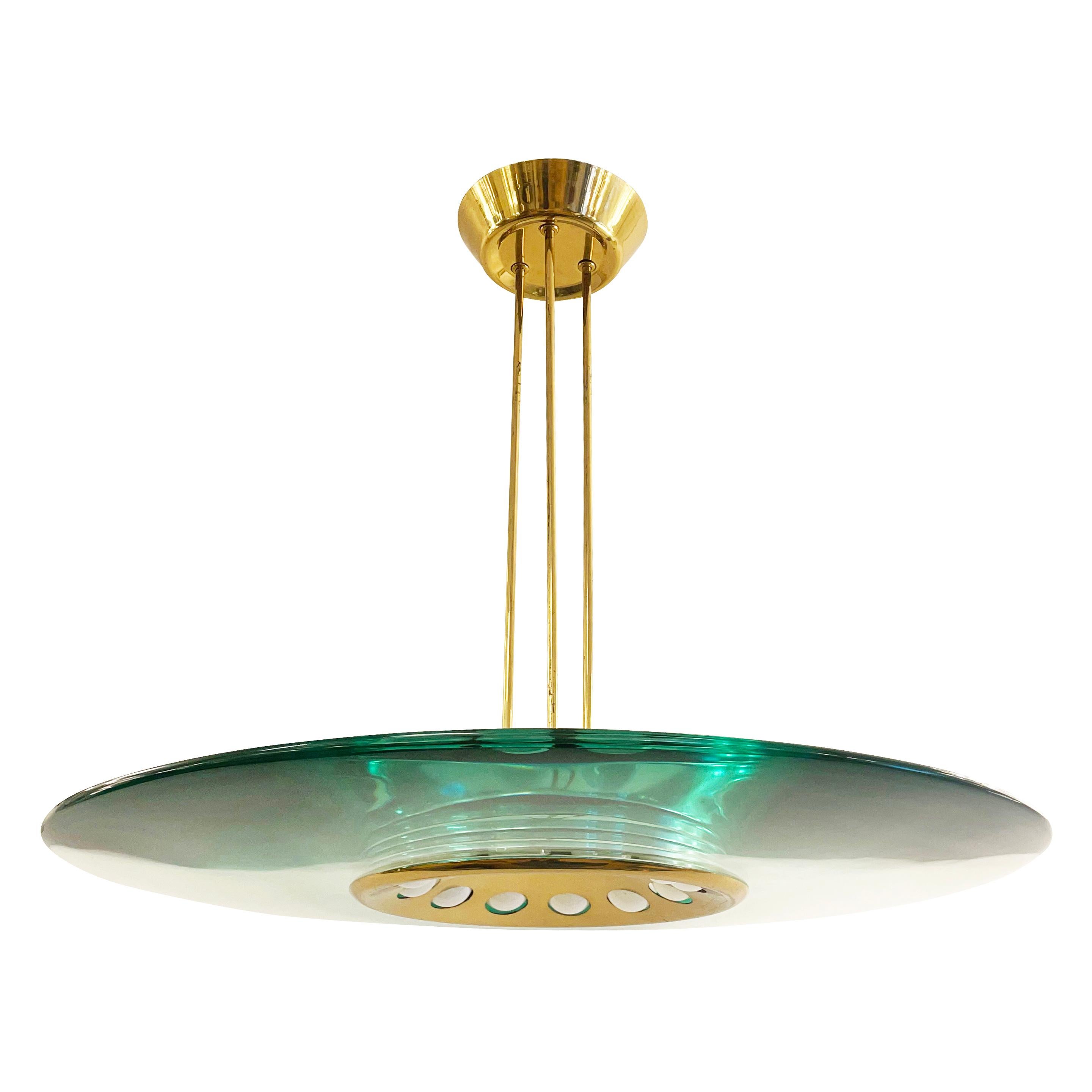 Fontana Arte chandelier model 1441 designed by Max Ingrand in the late 1950s. Features a thick and clear glass with a tint changing from green to turquoise depending on the angle its viewed from. The brass frame with three stems holds twelve