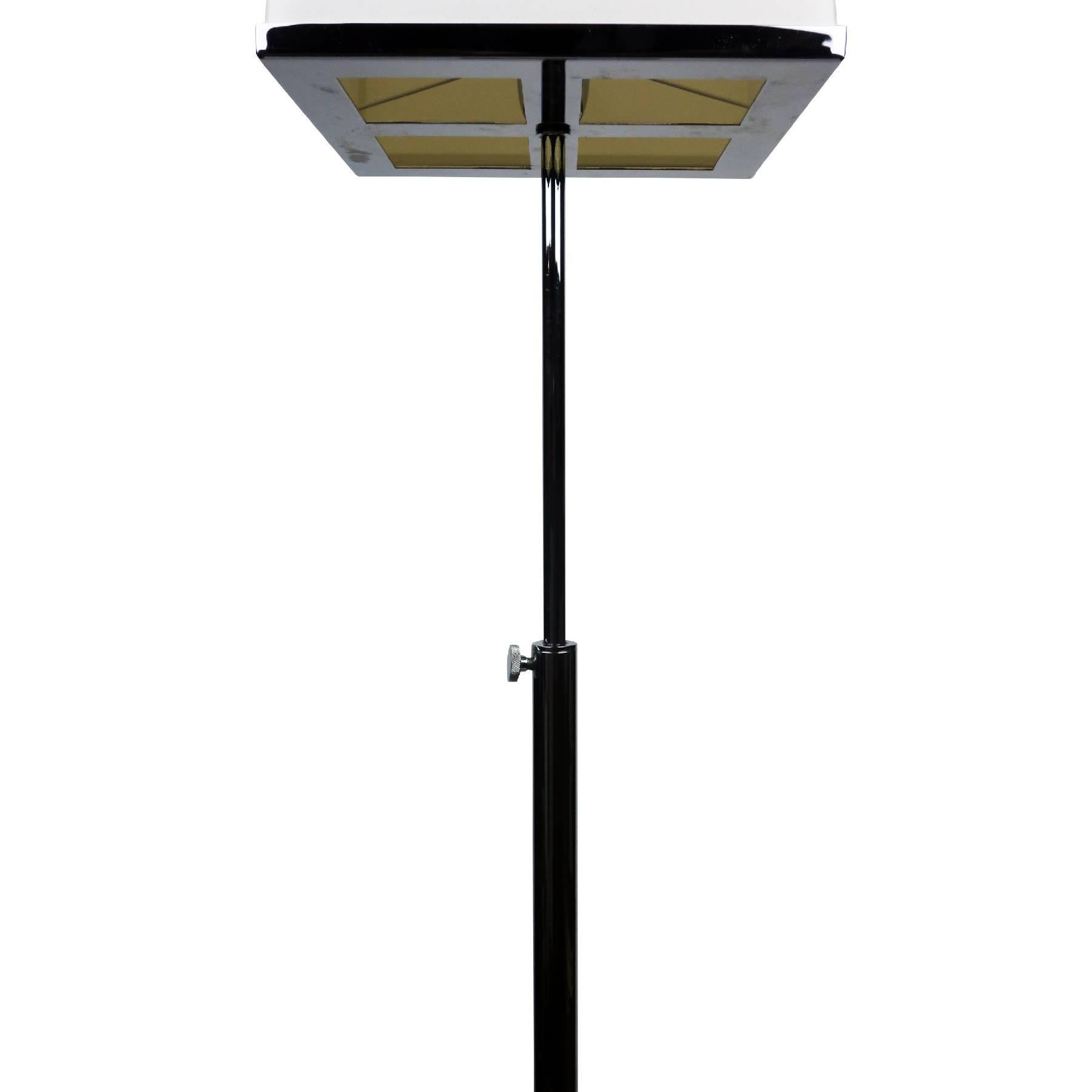 Manufactured by Fontana Arte, this contemporary floor lamp has a chromed metal base, stem, and shade holder, along with a chrome knob on the stem to adjust the lamp’s height. A new custom-built square lampshade sits securely on top and tapers in