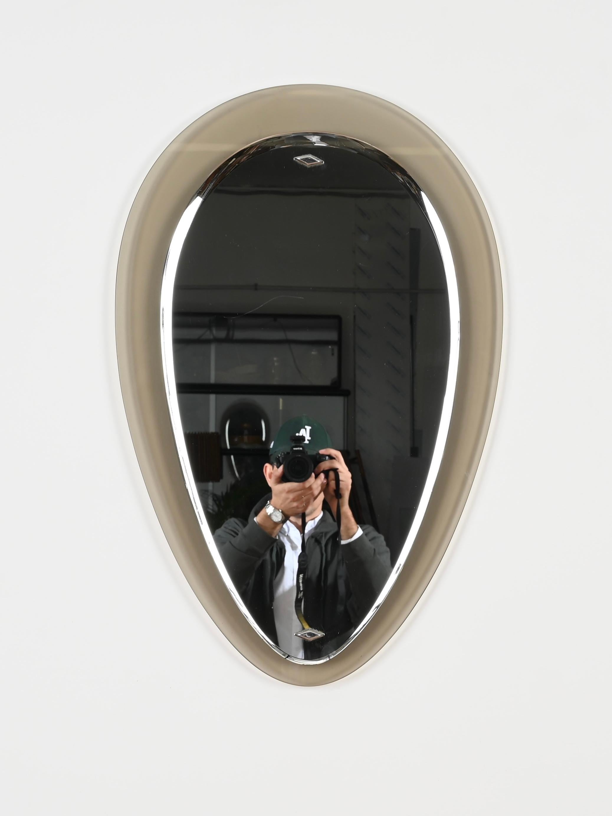 Outstanding oval drop-shaped mirror with fabulous dove grey green crystal frame and a central beveled mirror. The design of this incredibly elegant and rare mirror is attributed to Max Ingrand for a Fontana Arte production.  

The quality of the