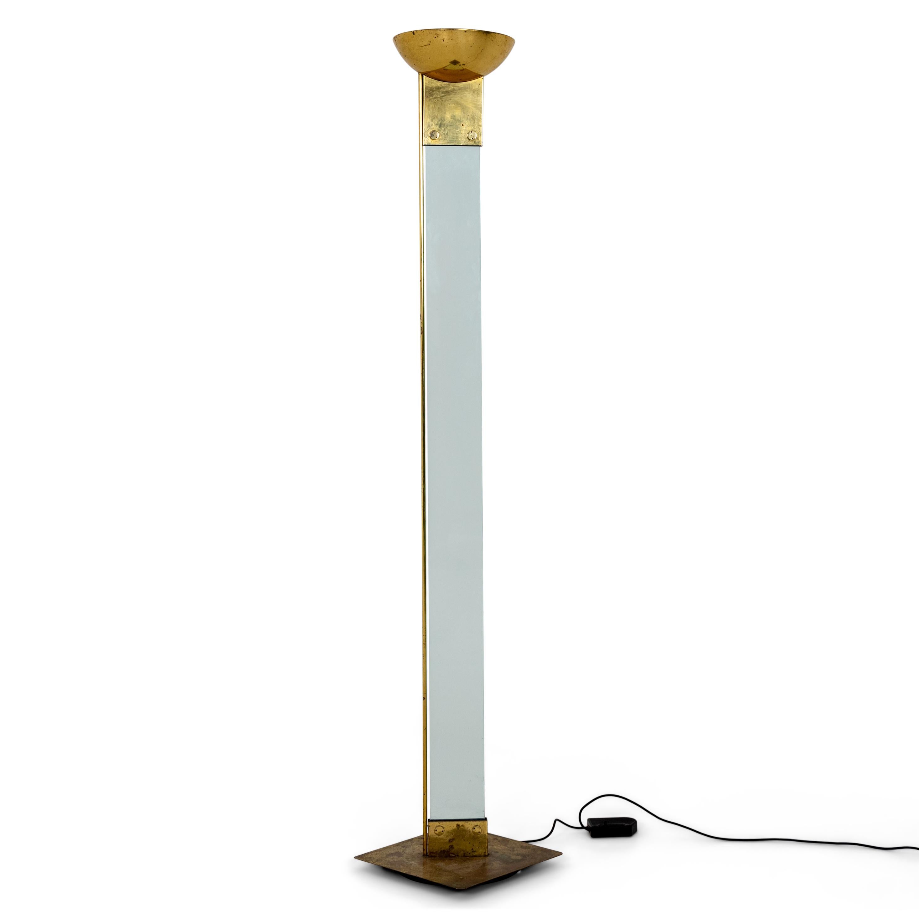 Floor lamp with brass conical lampshade and flat glass stem over square base.