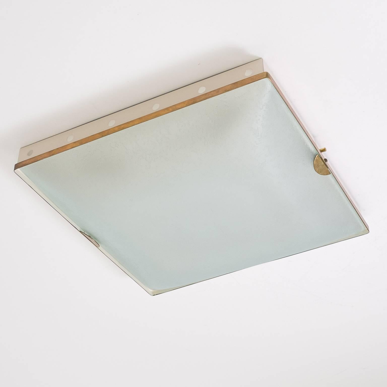 Excellent Fontana Arte flush mount (Model 1940), circa 1960. An off-white lacquered backplate with a brass rim holds a textured and satinated curved glass difusor. Four E14 sockets with new wiring.