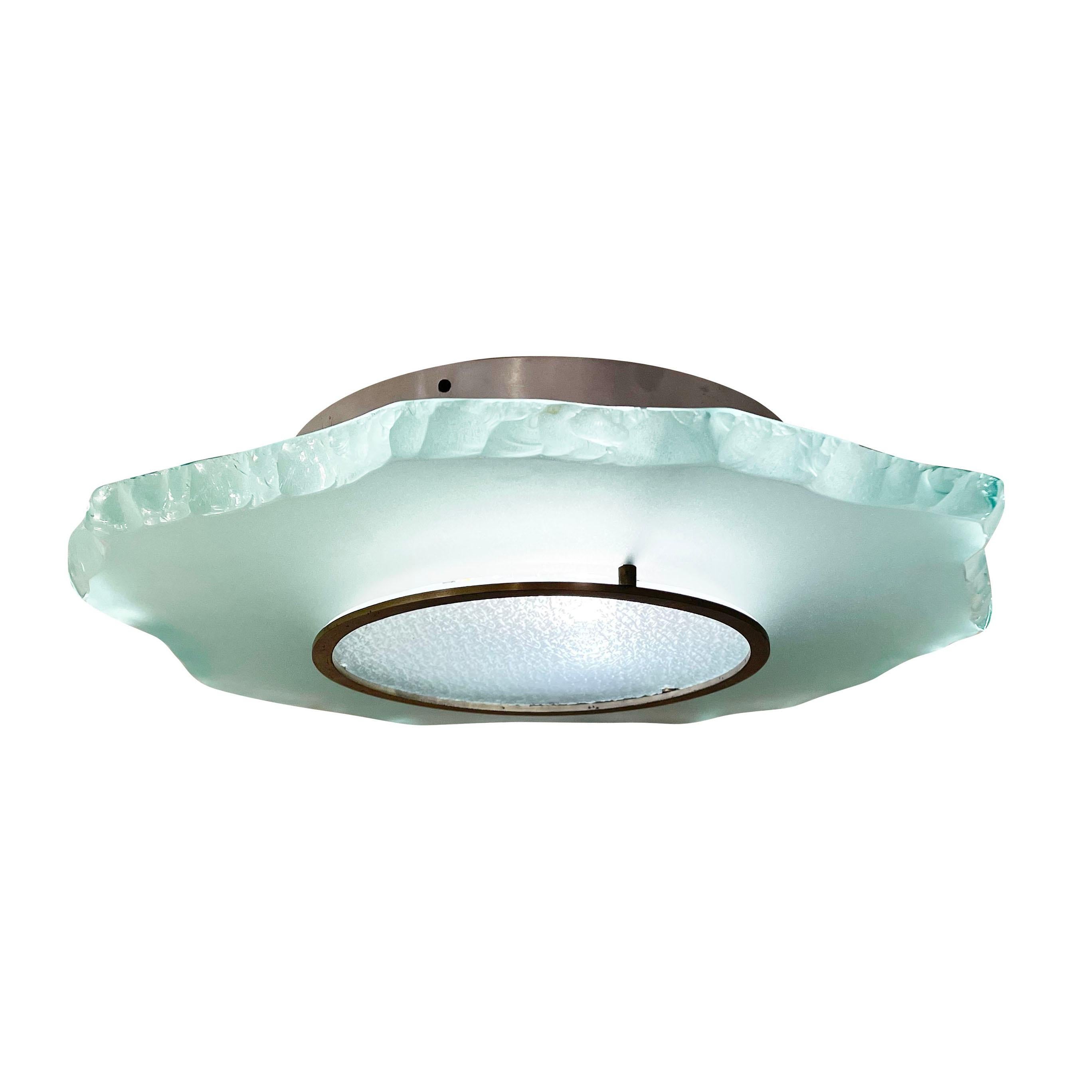 Fontana Arte flush mount light model 2312 designed by Max Ingrand in the 1950s. Features a central molded glass and an irregular thick glass halo. The glass has the classic Fontana Arte green tint to it. Hardware is brushed nickel. Holds three E26