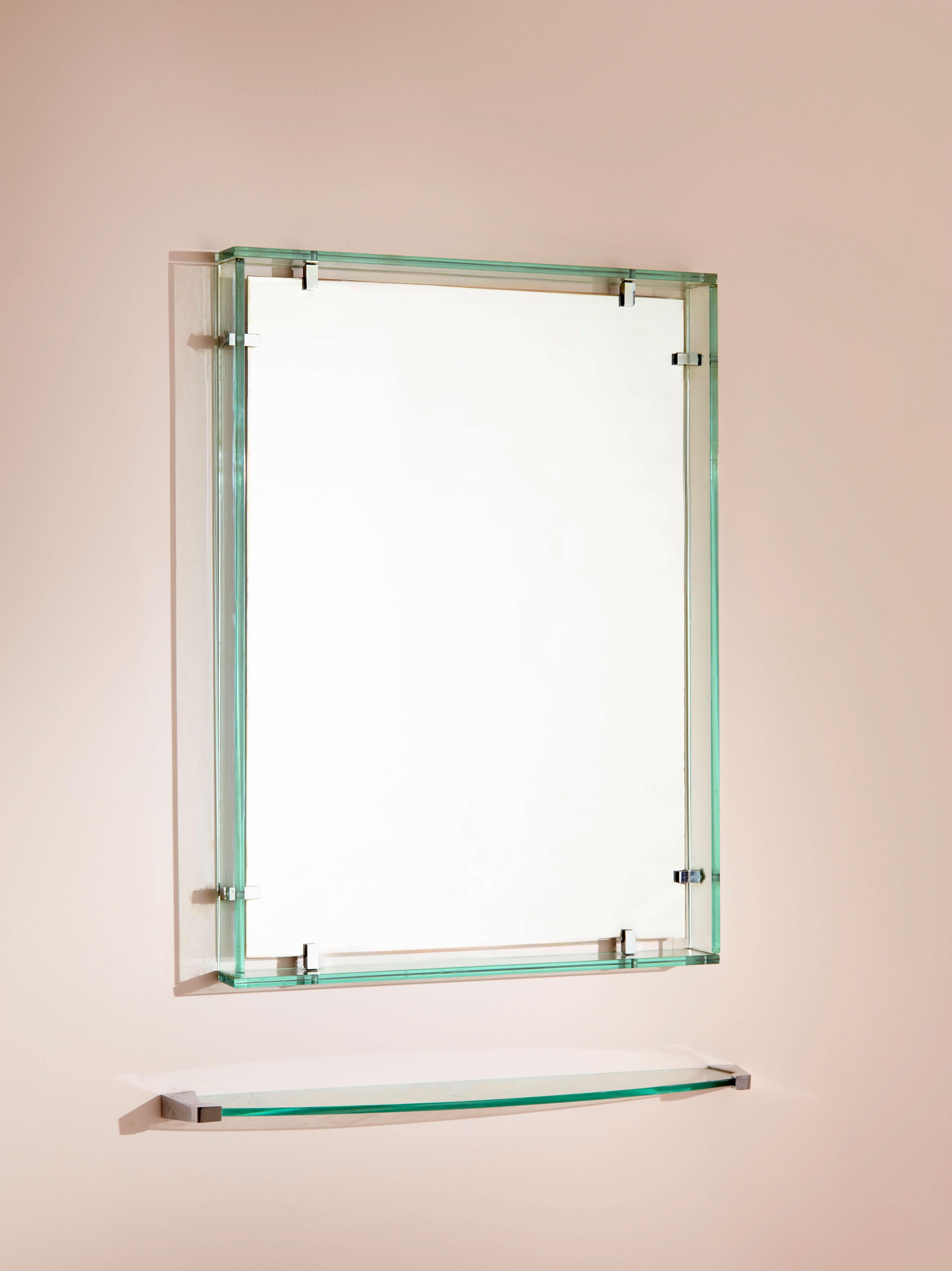 Max Ingrand para Fontana Arte, espejo rectangular, modelo 2014 con estante. Este elegante diseño presenta gruesas tiras de cristal verde claro que enmarcan la superficie espejada original, sujetas por soportes de clip de latón niquelado. Diseñada y