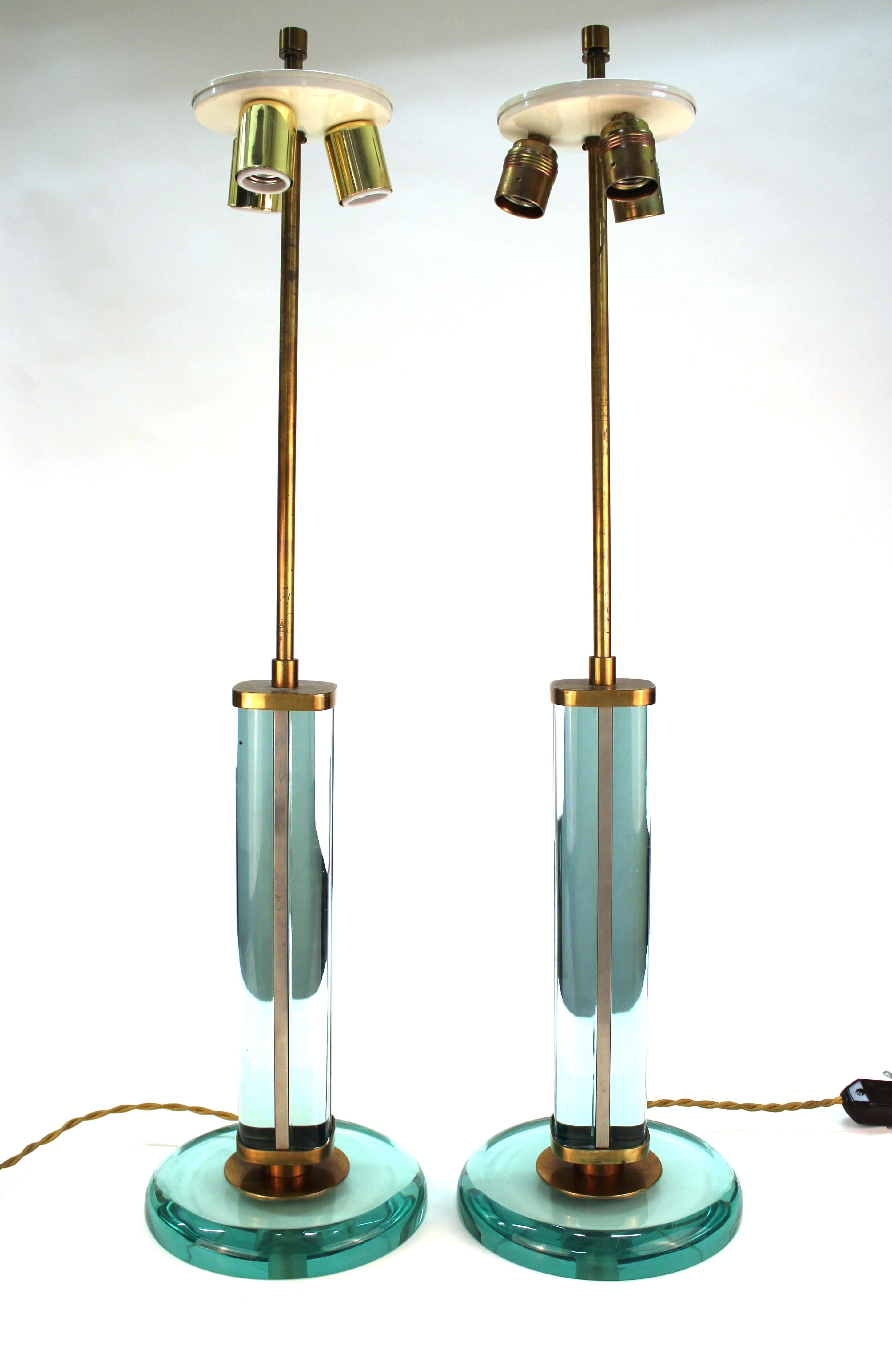 Fontana Arte Italian modernist table lamps in heavy aquamarine partially
mirrored glass and metal, attributed to Italian designer Pietro Chiesa. The pair was made in Italy in the 1940s. The glass in the shaft is partially mirrored, atop a heavy