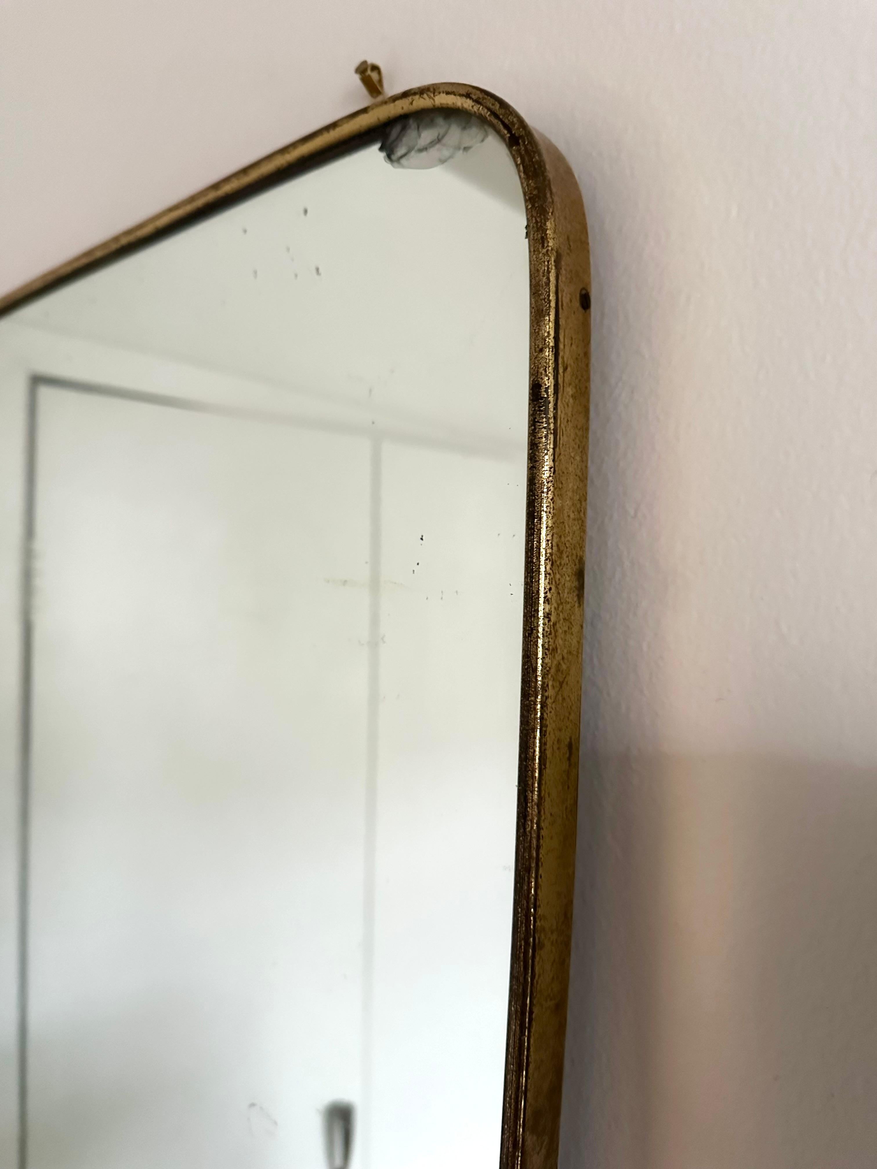 Elegant and large rectangular brass framed wall mirror with gently tapering sides. Backed with wood panel.
