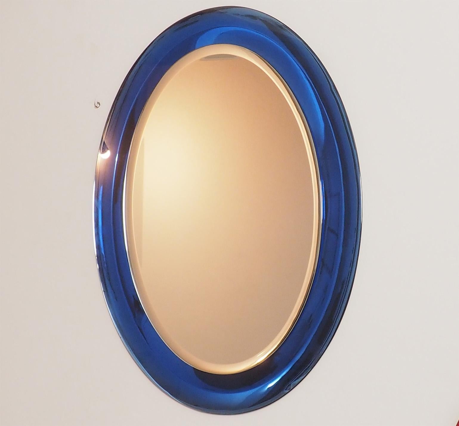 Fontana Arte large blue oval mirror, with a partial visible label on the back
Thanks to the back beveled mirrored blue frame it creates a beautiful reflex on the front.
The beautiful tone of blue together with the large proportion of the oval