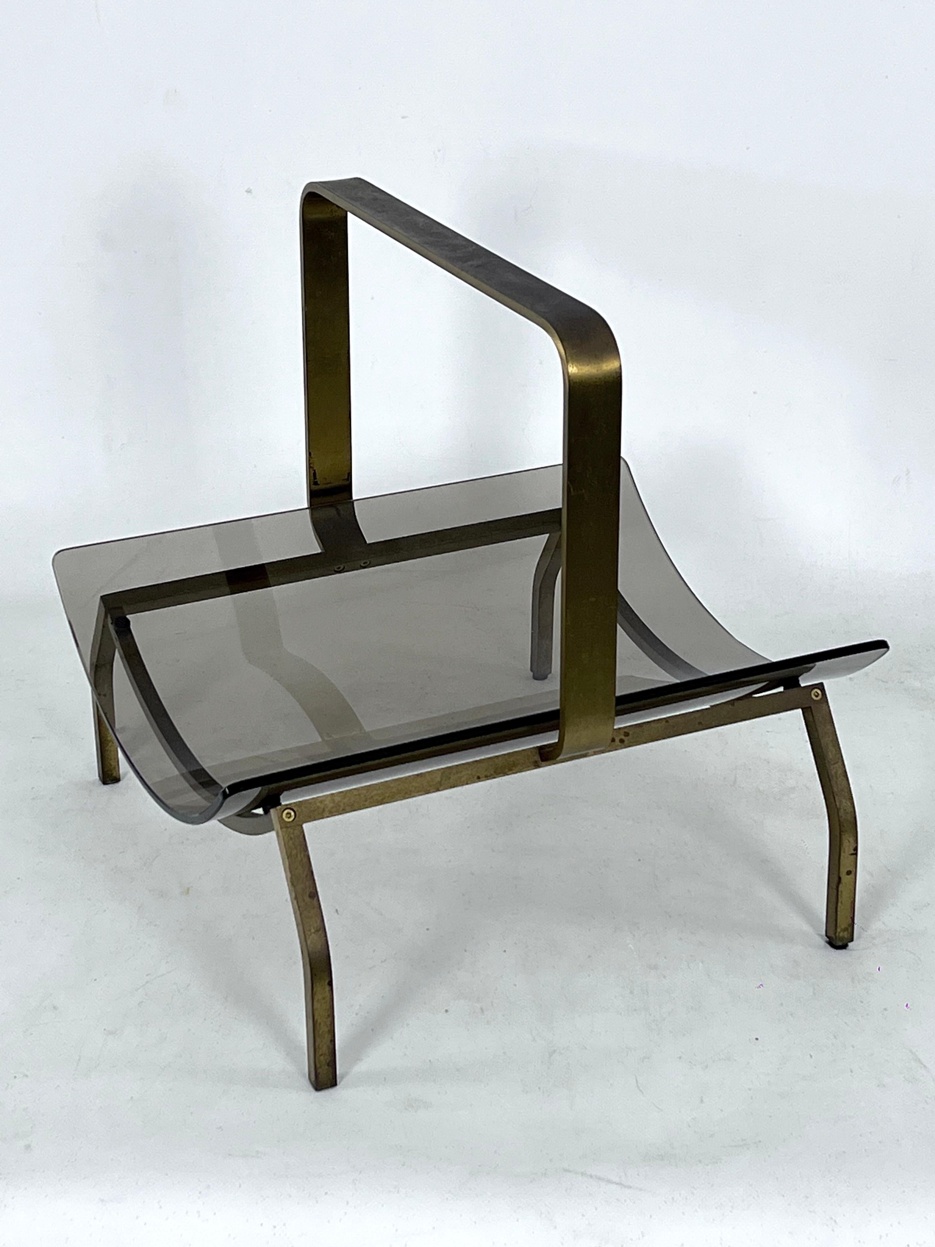 Great vintage condition with normal trace of age and use for this magazine rack made from solid brass and curved glass. Manufactured in Italy during the 60s and produced by Fontana Arte.