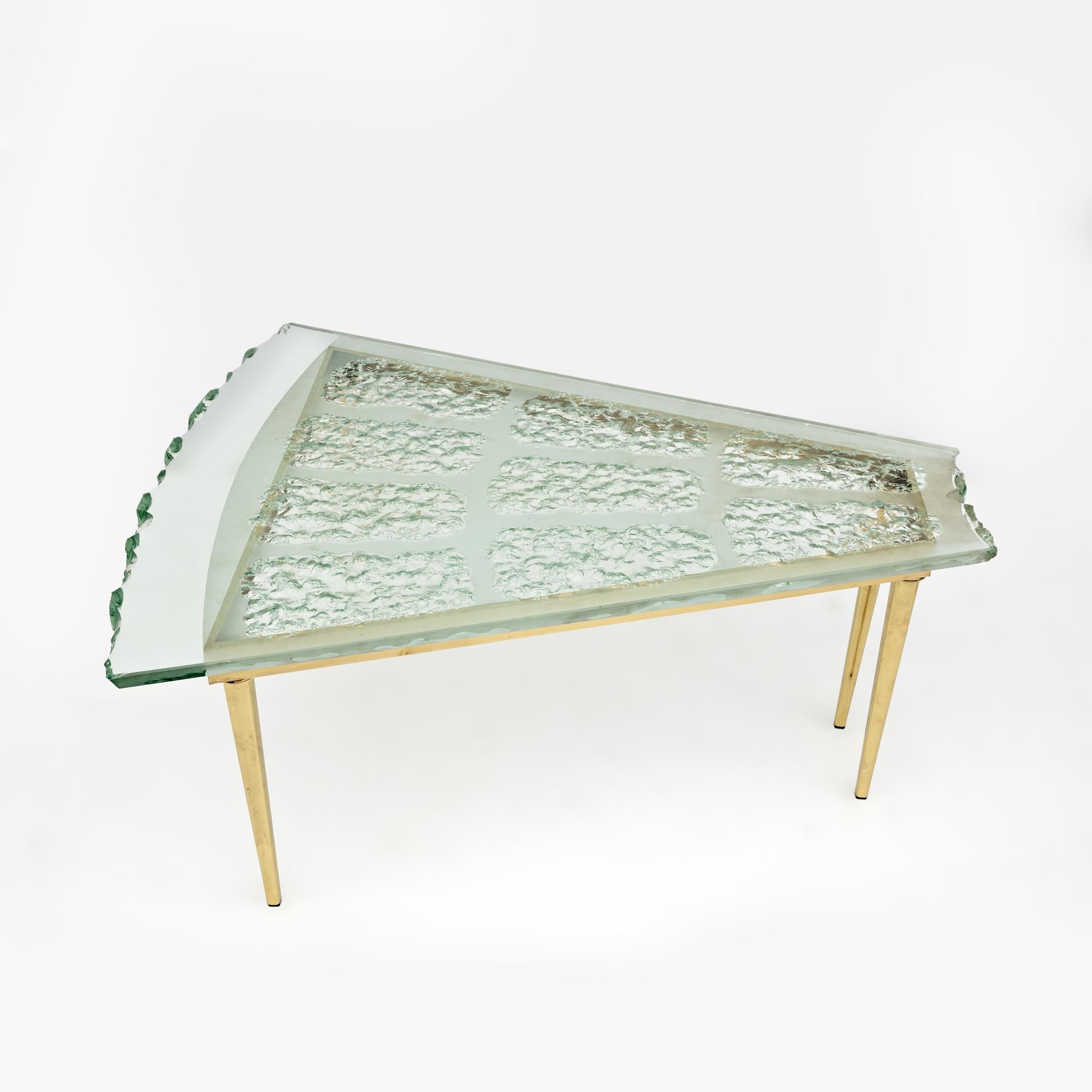 Extraordinary mid-century Italian coffee table in hand-chiselled and frosted Murano glass, attributed to Max Ingrand and produced by Fontana Arte. The detailed engraved coffee table is supported by a brass frame, sitting on four feet. This table can