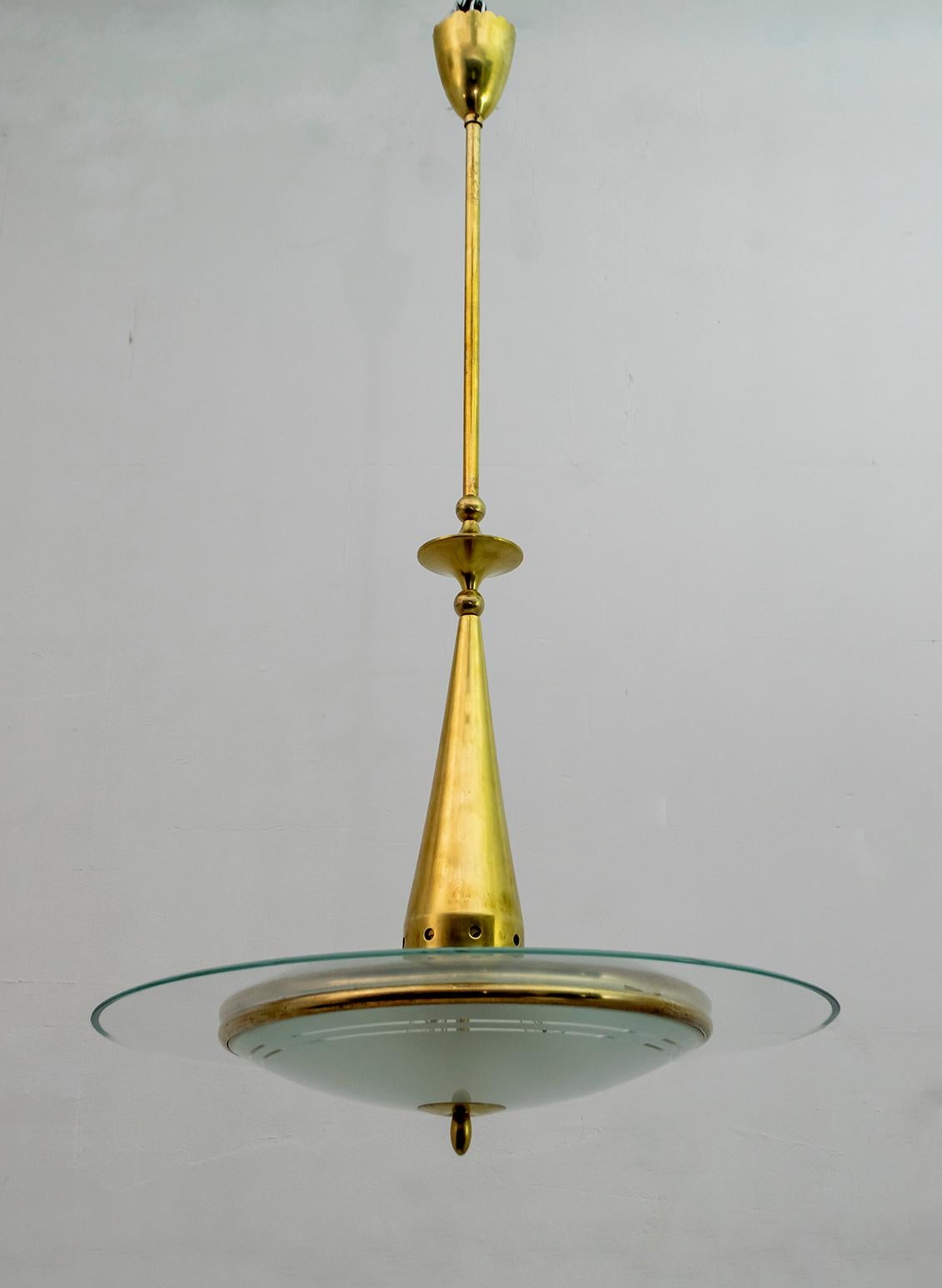 Beautiful Italian chandelier made by Fontana Arte, 1950s. The chandelier has a brass structure, the pendant is made with a cup that covers the wires in the upper part, in the center we find geometric elements in brass for ornament. From the center