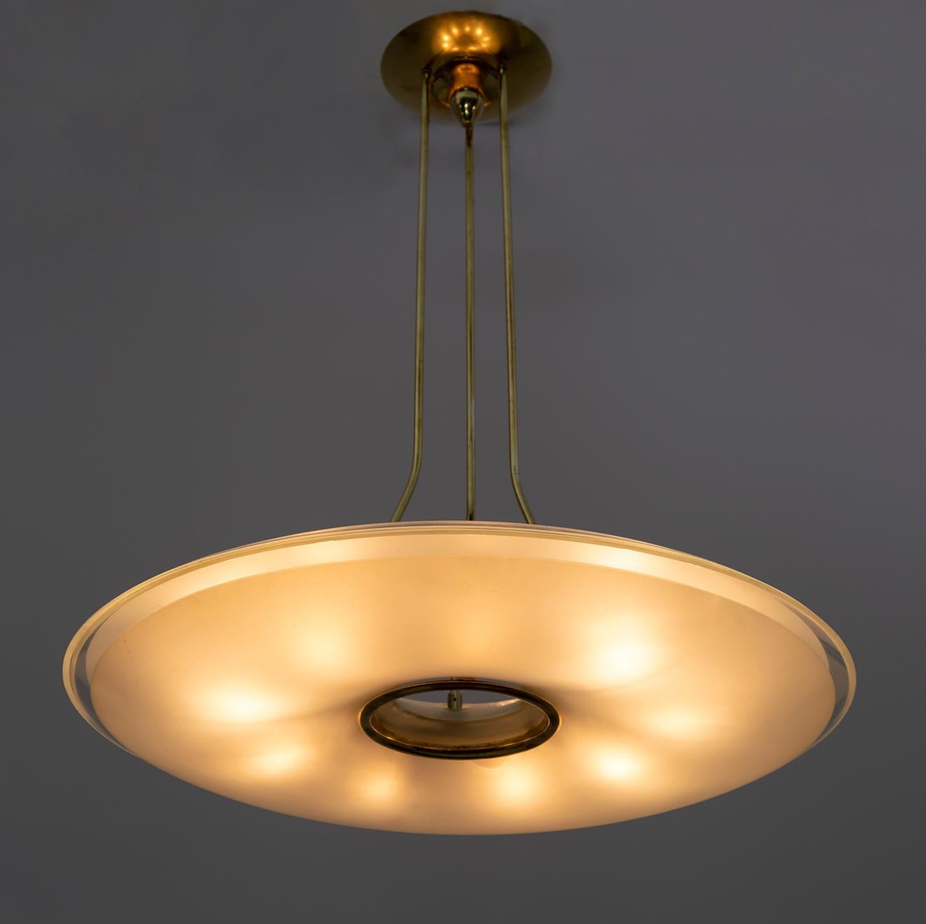 Chandelier attributed to Max Igrand for Fontana Arte, Italy, circa 1950s. Cast brass and curved crystal. Two large curved etched glass lampshades mounted on a brass frame, at first glance it is in excellent condition, has small chips and two cracks