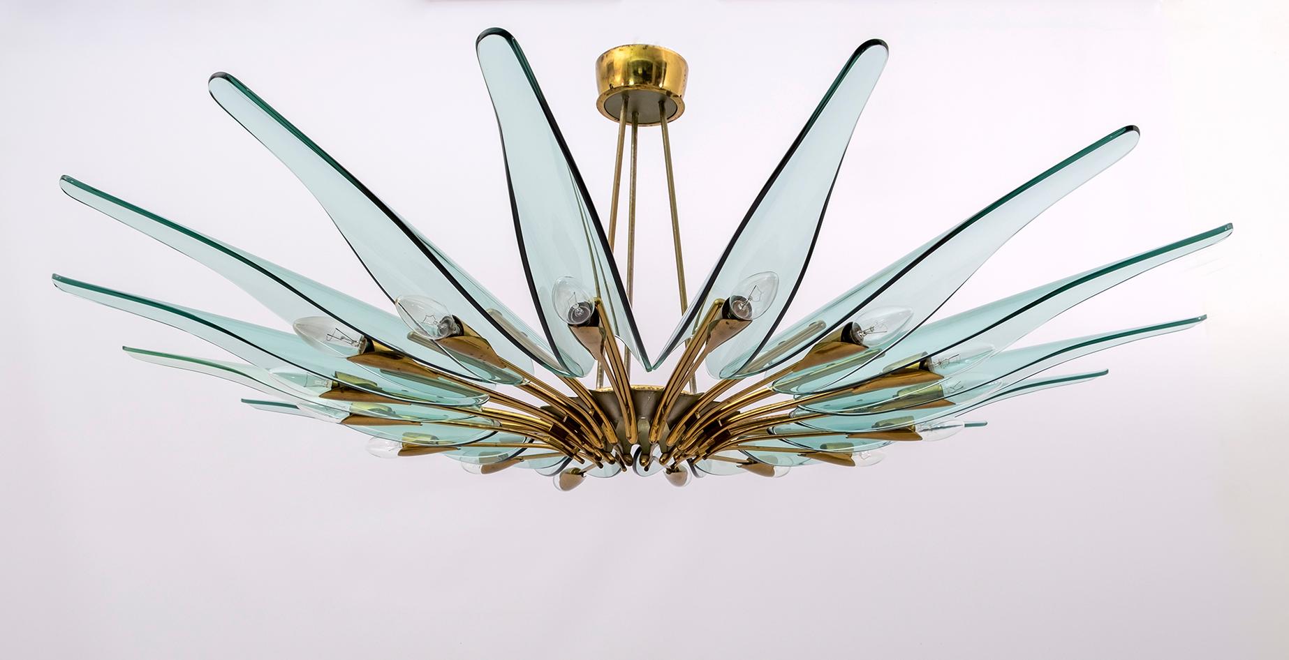 To consider is the Dahlia chandelier mod. 1563A with 16 lights by Max Igrand for Fontana Arte, Italy, circa 1950s. Cast brass and curved crystal. Excellent original condition of the time, not restored. The crystal has a shade of green. The brass has