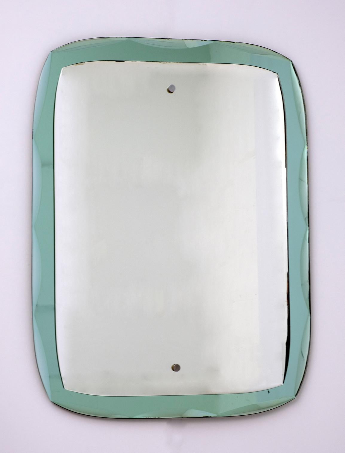 This heavy wall mirror features the green beveled mirror and the traditional mirror always with the grinding, typical of the Fontana Arte production. It has time spots on the edges but this does not diminish the quality of the mirror.

Fontana
