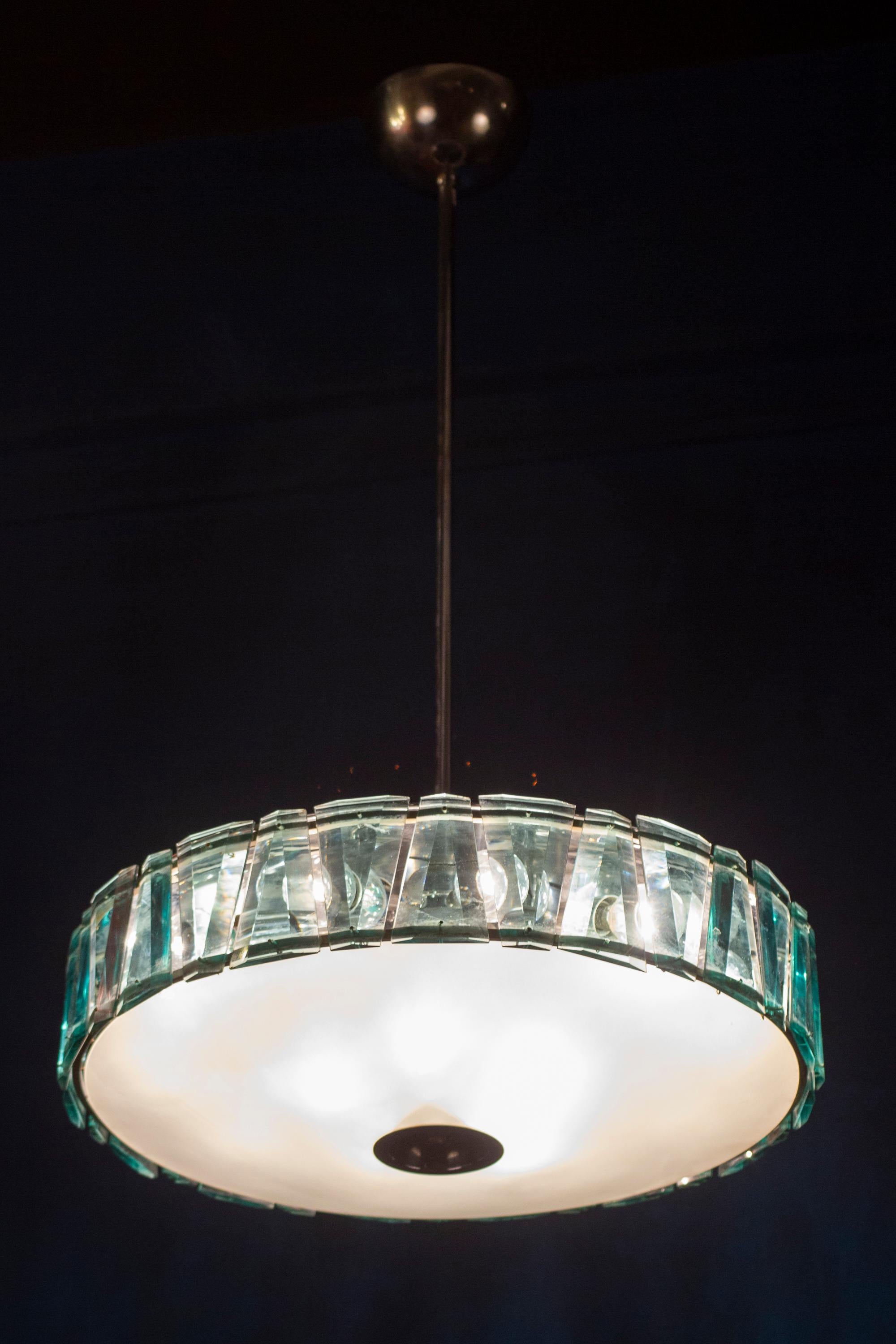 Striking Minimalist Stilnovo pendant Model 1273 , with a frosted  opaline glass bowl surrounded with ground green cut crystals, supported by polished chrome hardware.
The glasses are in perfect condition.
15 E 14 lightbulbs. We can rewire for your