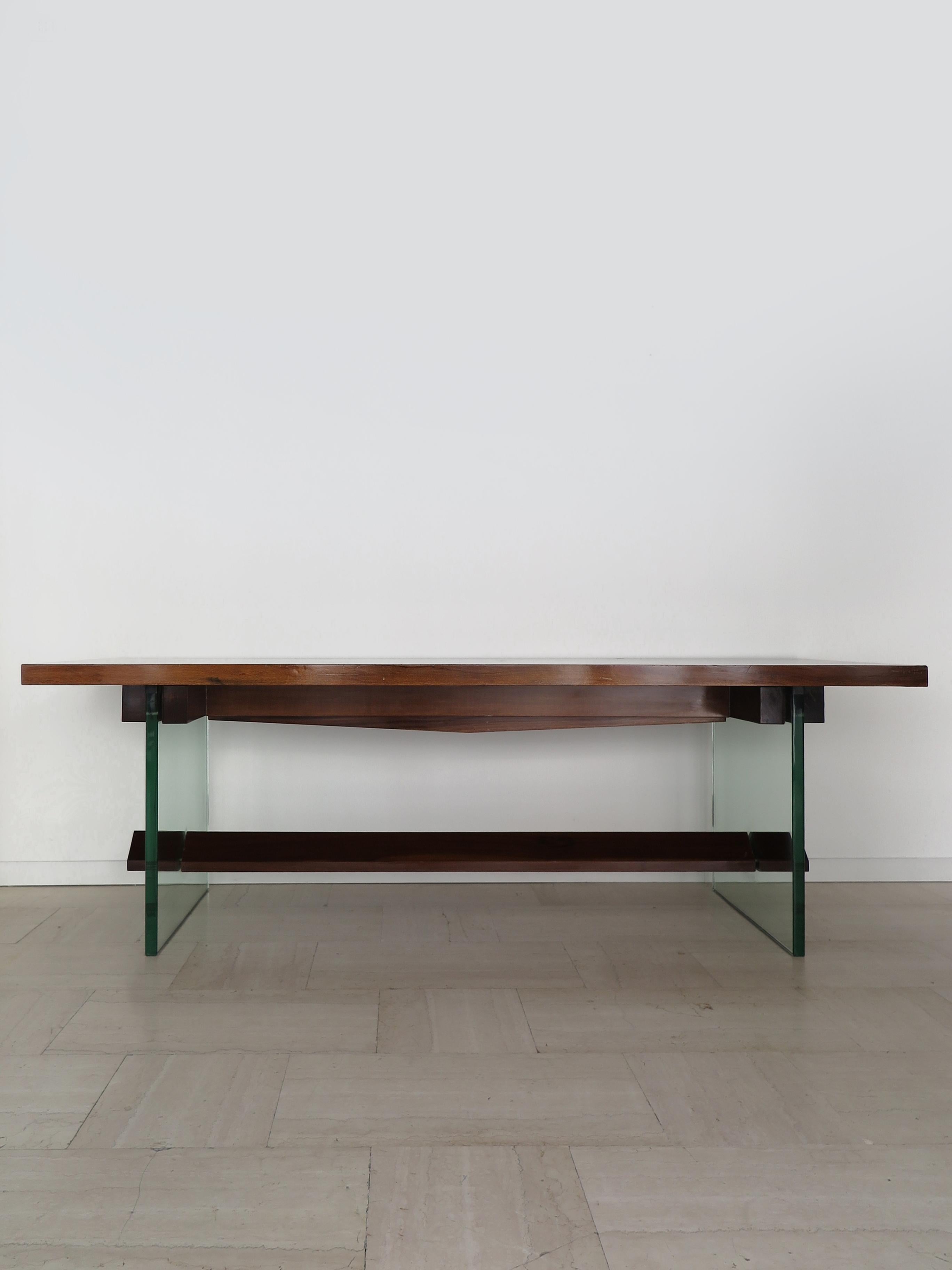 Grande table de salle à manger ou consolle italienne au design moderne du milieu du siècle dernier, conçue et produite par Fontana Arte, avec plateau et repose-pieds en bois et épais pieds en verre pilé, fabriquée en Italie dans les années 1960.