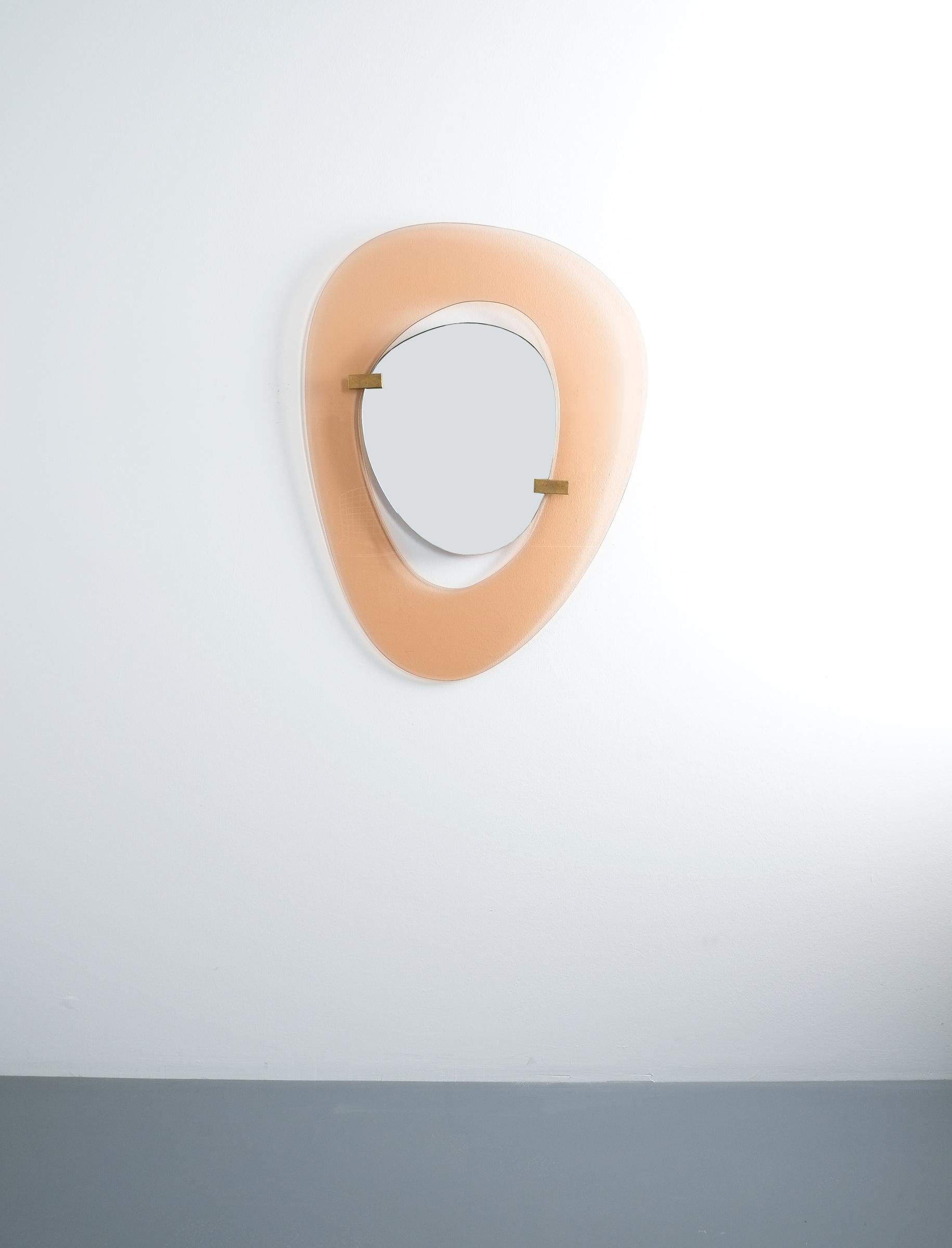Fontana Arte mirror by Max Ingrand, Italy, circa 1958. Beautiful mirror with an anomic orange/apricot smooth glass frame and anomic floating mirror attached with two brass clasps.
Measurements are 23.6