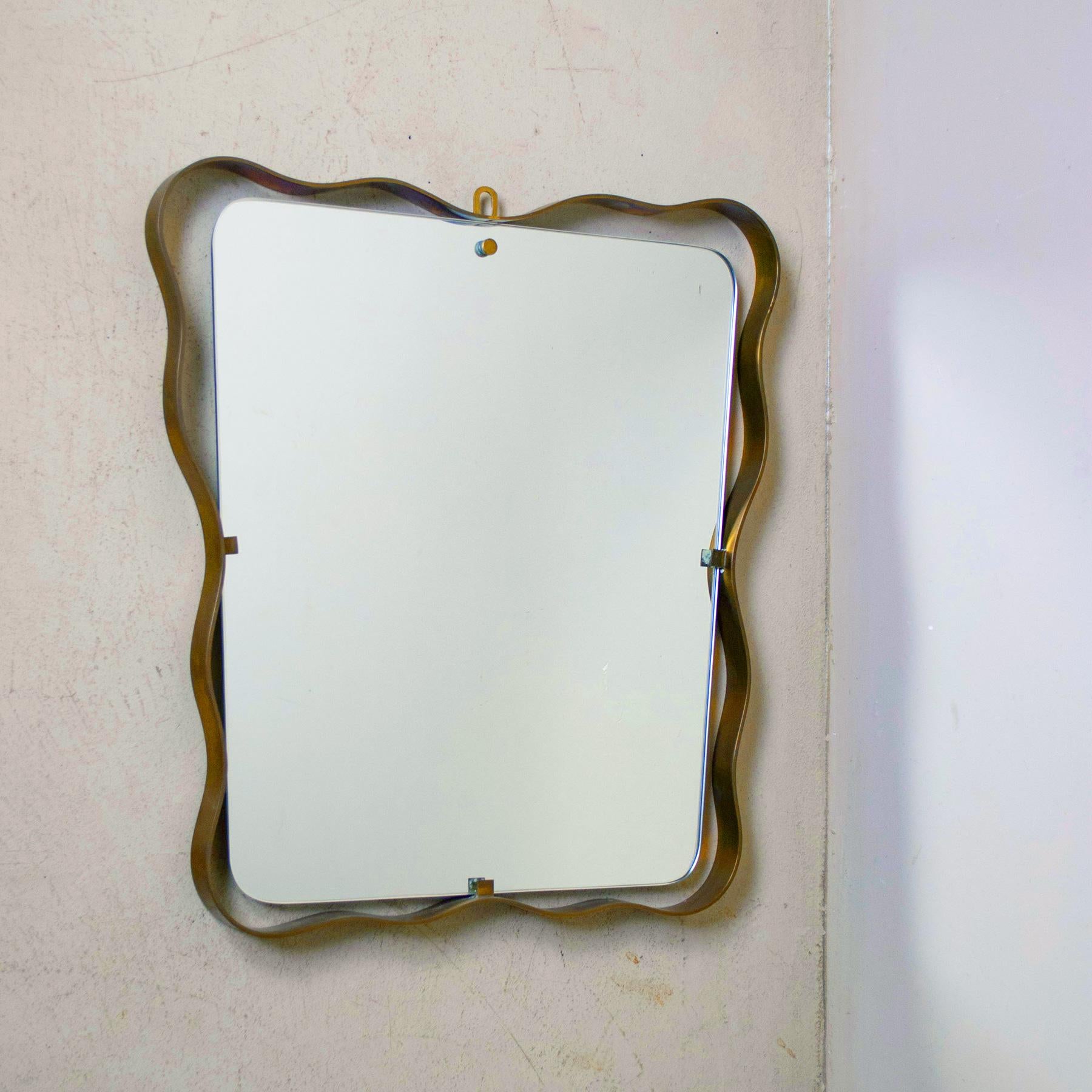 1950s elegant mirror with curved brass frame Fontana Arte attributed.