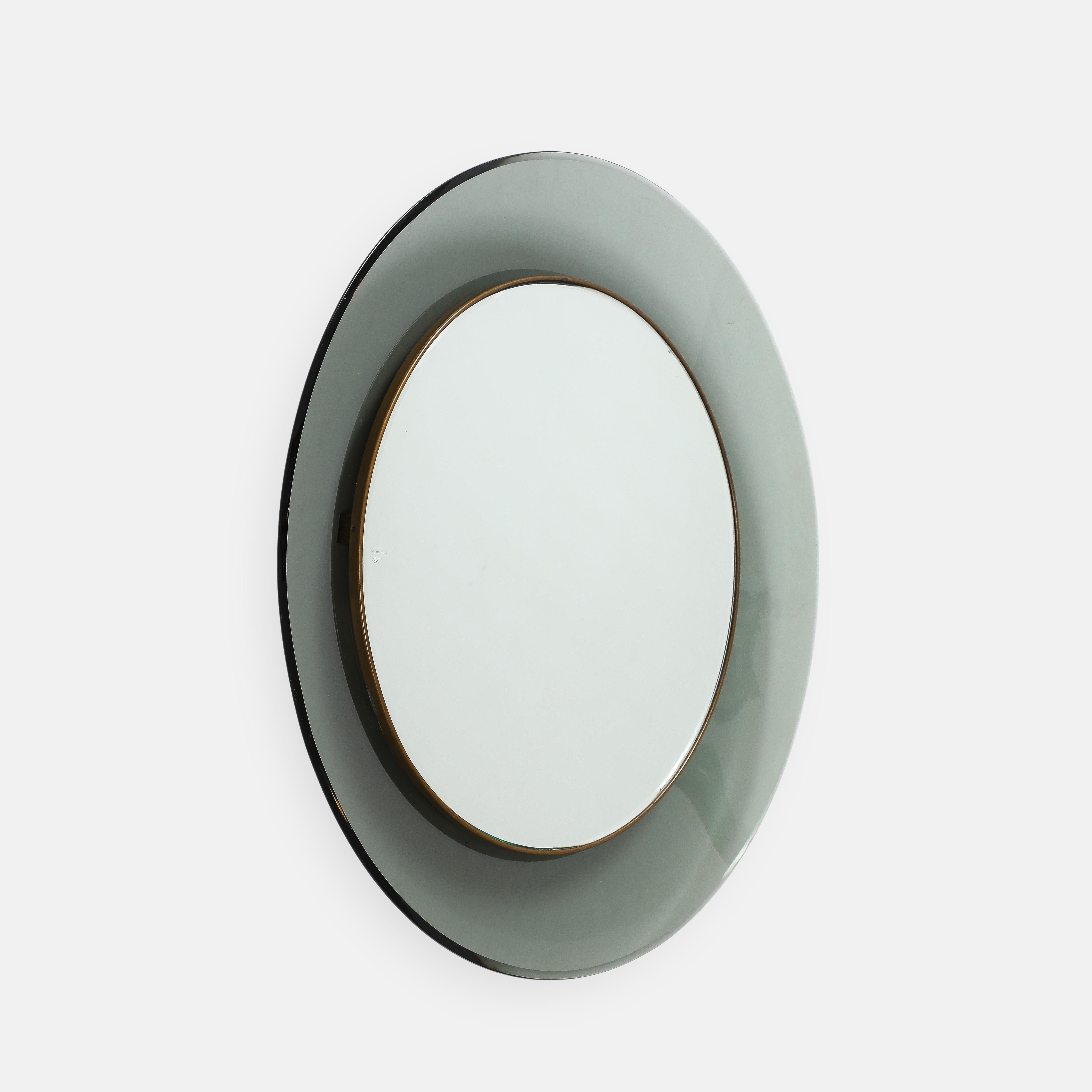 Max Ingrand for Fontana Arte classic and elegant round mirror model 1669 in gray-green colored, curved and beveled glass framing mirrored glass encased in brass trim.  
Dated on reverse '28 ago 1963.'

Literature:
Quaderni Fontana Arte 2,