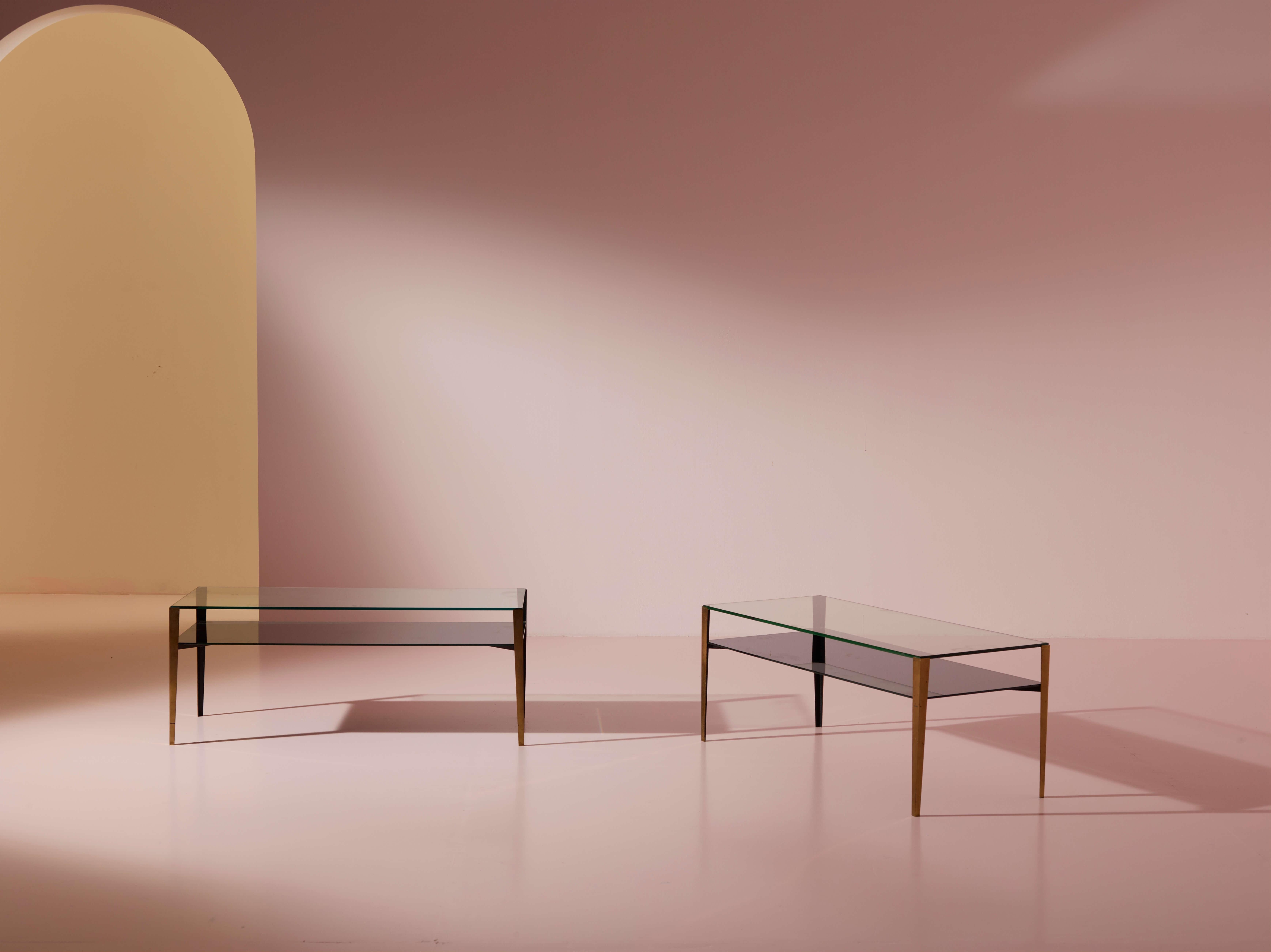 A pair of brass and glass coffee tables, model 2341, produced by Fontana Arte in the 1960s, featuring a transparent glass top and a mirrored glass lower shelf.

Brass and glass; a combination that defines the finest works of Fontana Arte, a brand