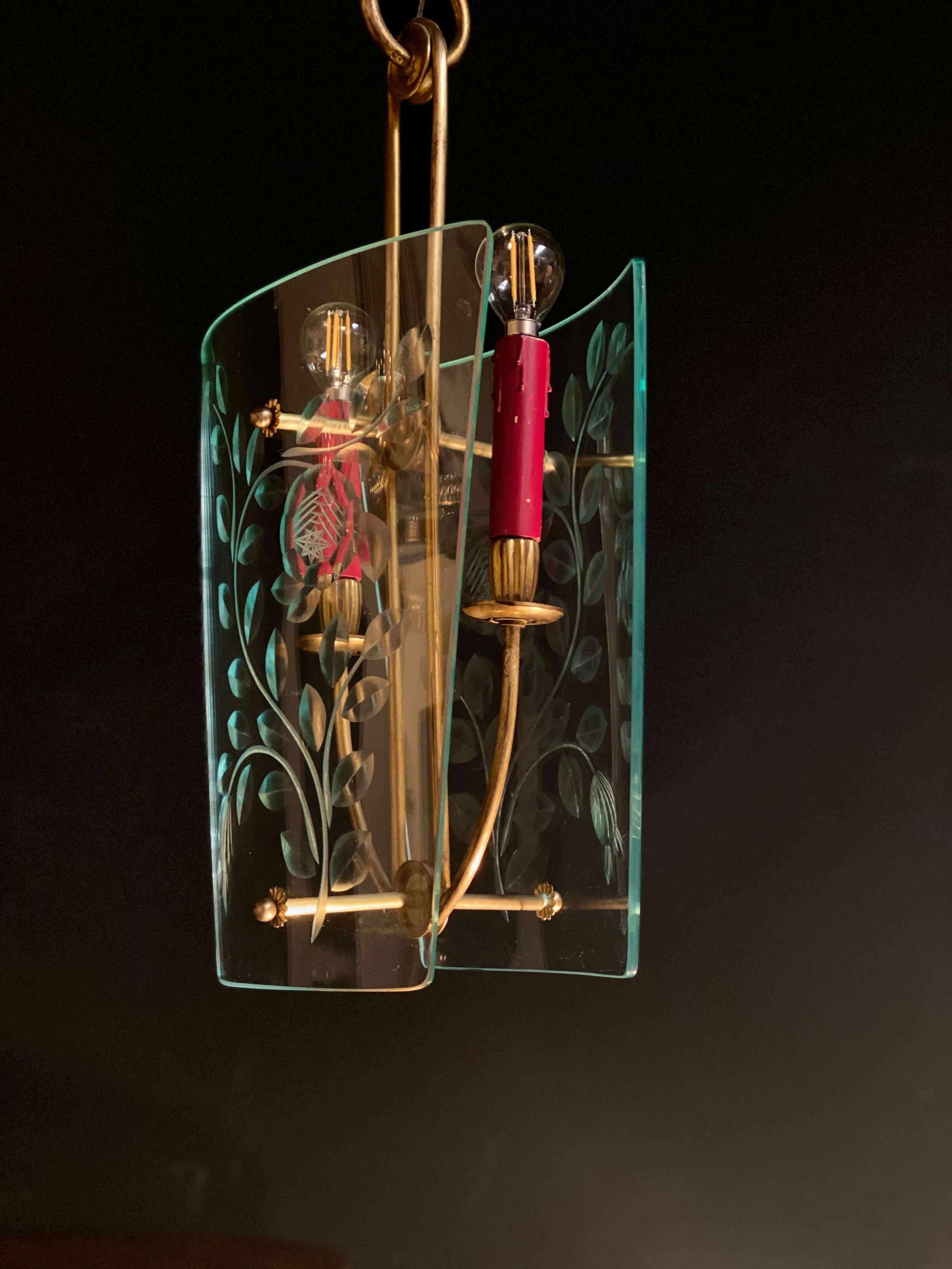 Rare pair of pendants attributed Pietro Chiesa for Fontana Arte. Two curved glass in Nile green crystal with precious etched acid decoration with vegetal motif supported by a brass frame. Original red and green painted candles. We can wire for your