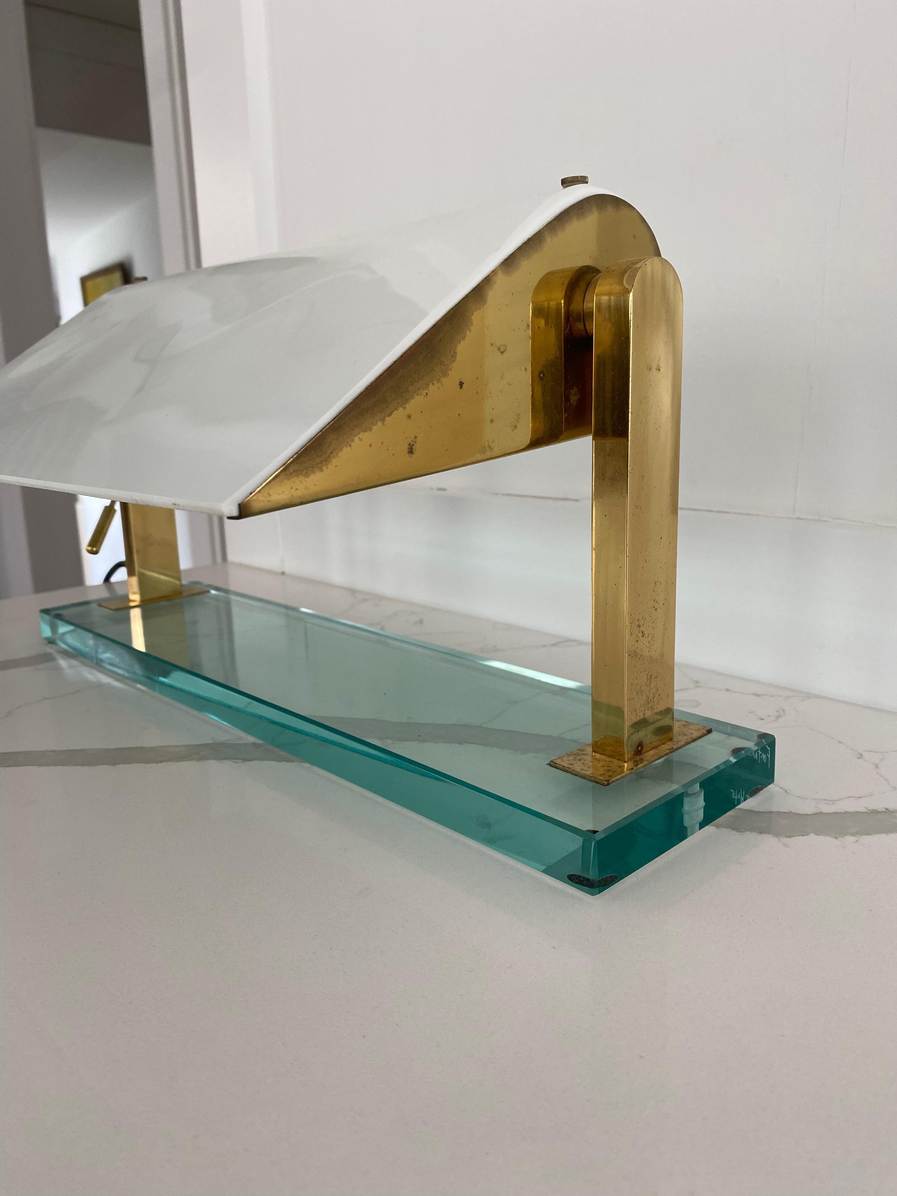 MODEL 0836 desk lamp by Cheese for Fontana Arte made of brass structure on crystal base with milk glass shade.

Glass shade rotates.

Base with etched signature 