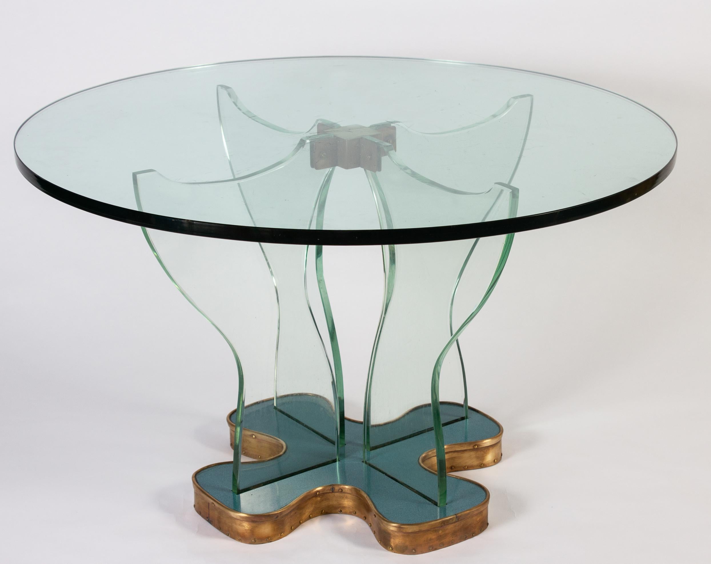 This outstanding table is made with thick green Nile glass, a typical feature of Fontana Arte's pieces.
Elegant design glass center legs on a blu four- leaf clover shaped base with brass finish.
Excellent original vintage condition.
 This table