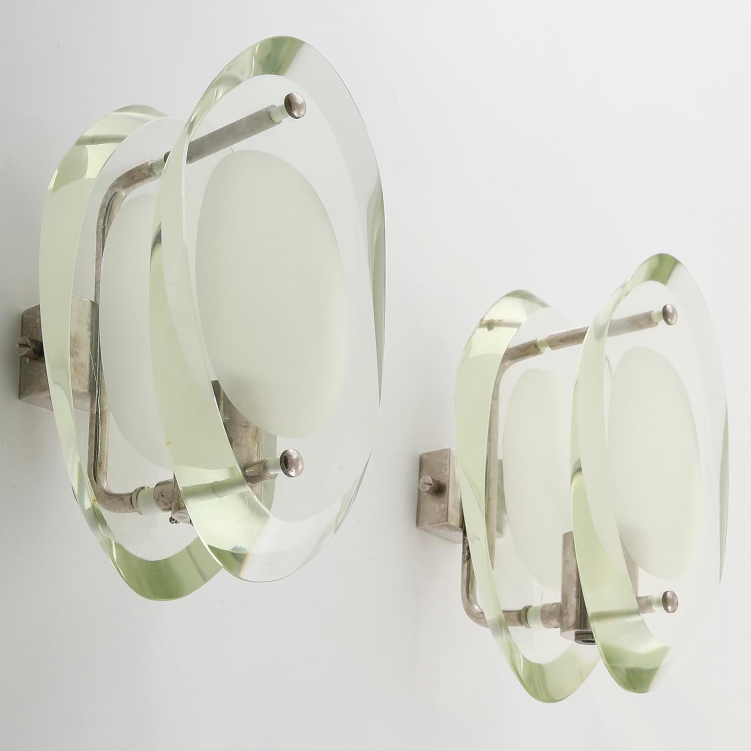 A pair of wall lights, model 'Micro' no. 2093 designed by French designer Max Ingrand for Fontana Arte, Italy, manufactured in midcentury, circa 1960.
A nickelled brass frame with patina and holds two organically shaped, partially frosted clear