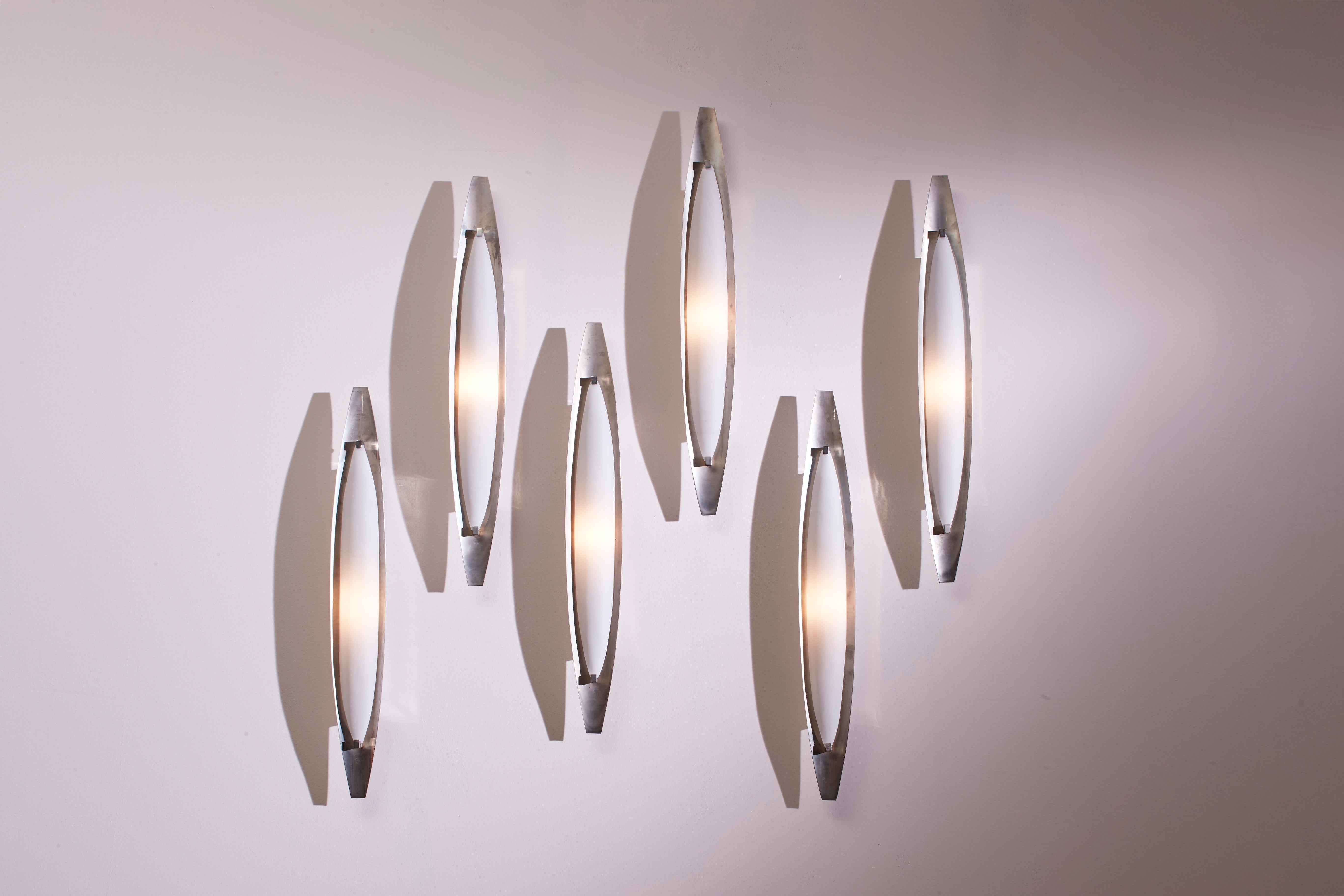 A set consisting of six wall lamps, model 2254, in brushed nickel-plated brass with satin white glass diffusers, produced by Fontana Arte, Italy, circa 1960.

Made of brushed nickel-plated brass, these lamps feature curved satin glass diffusers.