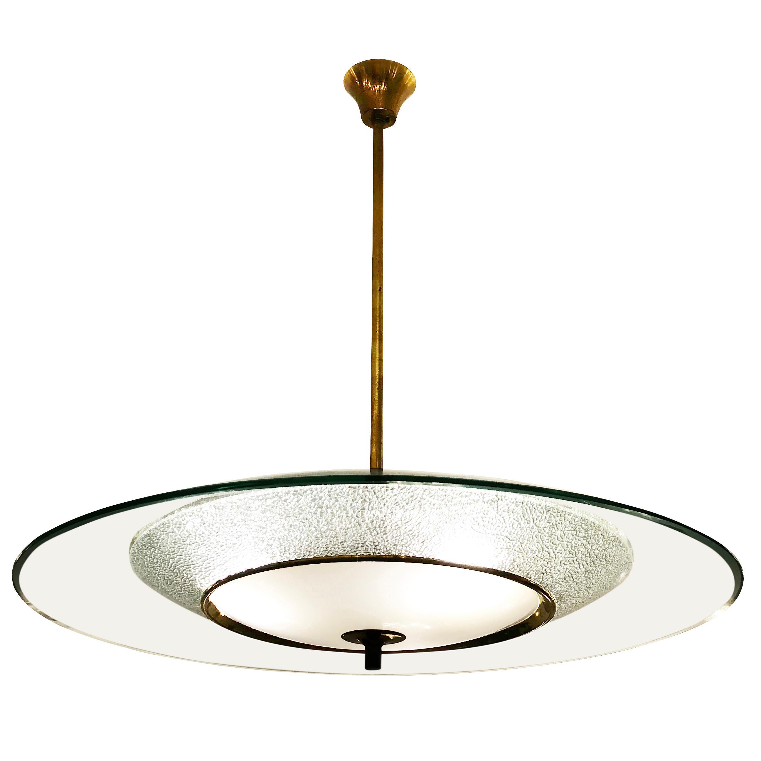 Italian midcentury ceiling light reminiscent of the work of Fontana Arte. The top concave glass is clear with beveled edges, the second has stunning texture and the third is white with a brass rim to hide the three light sources. Hardware is