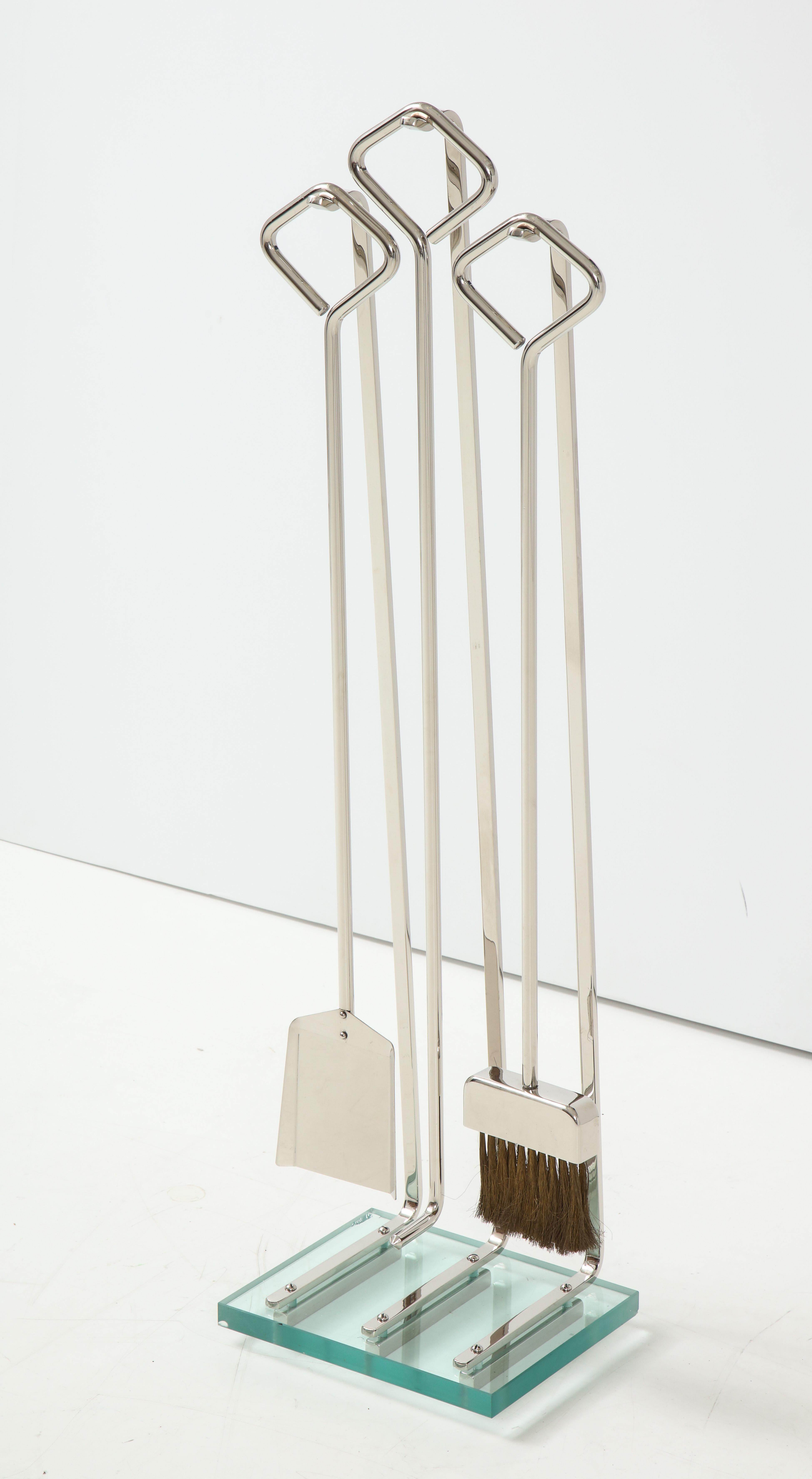 Modernist set of polished nickel fire tools in polished nickel on a glass base.
On display at 200 Lexington Avenue, 10th floor.