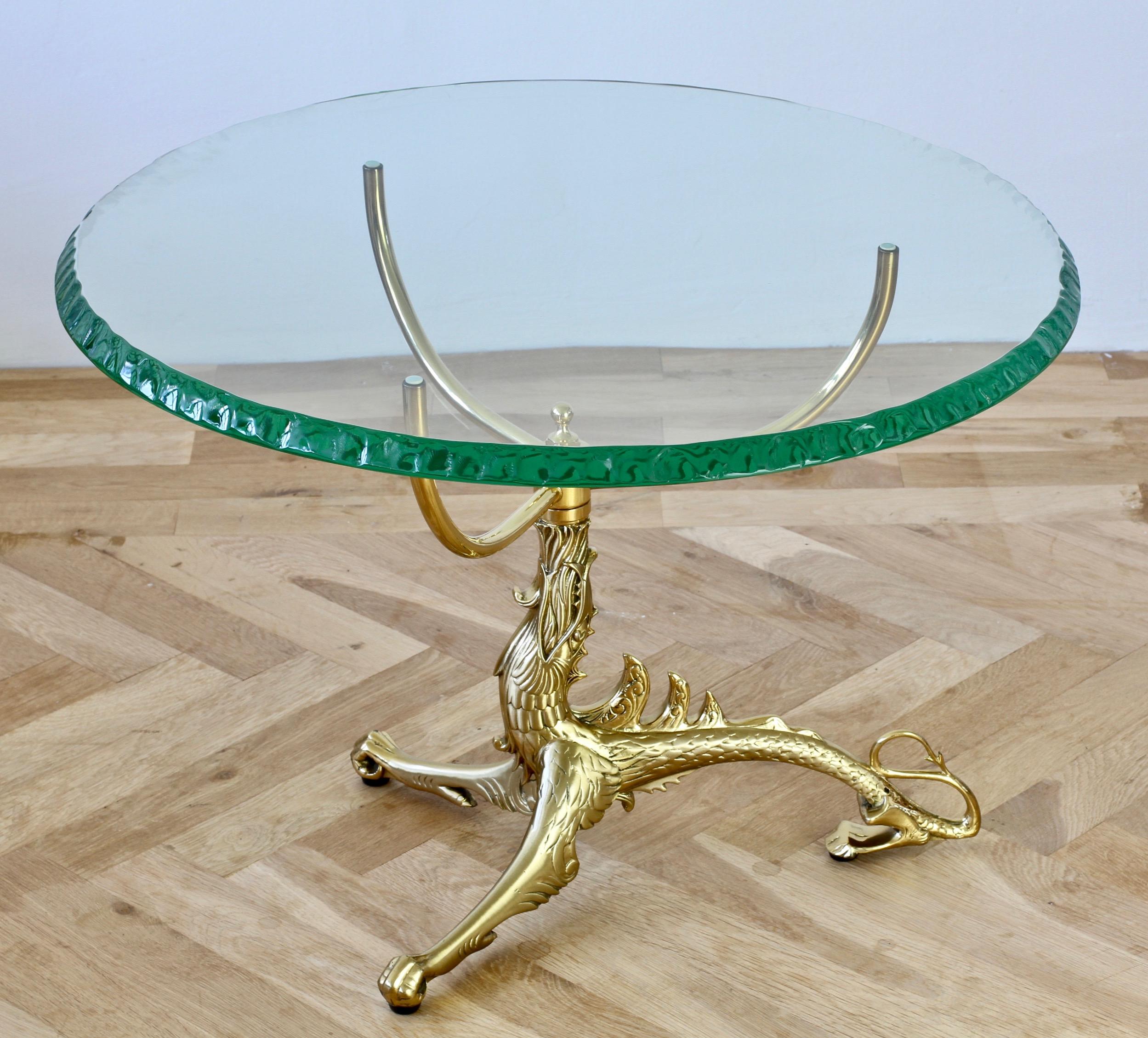 Midcentury French, Maison Jansen style, beautifully designed and handcrafted / cast brass dragon table with a thick hand chipped / chiselled green toned glass top in the manner of Fontana Arte, circa 1975. Cast in brass, the dragon support three