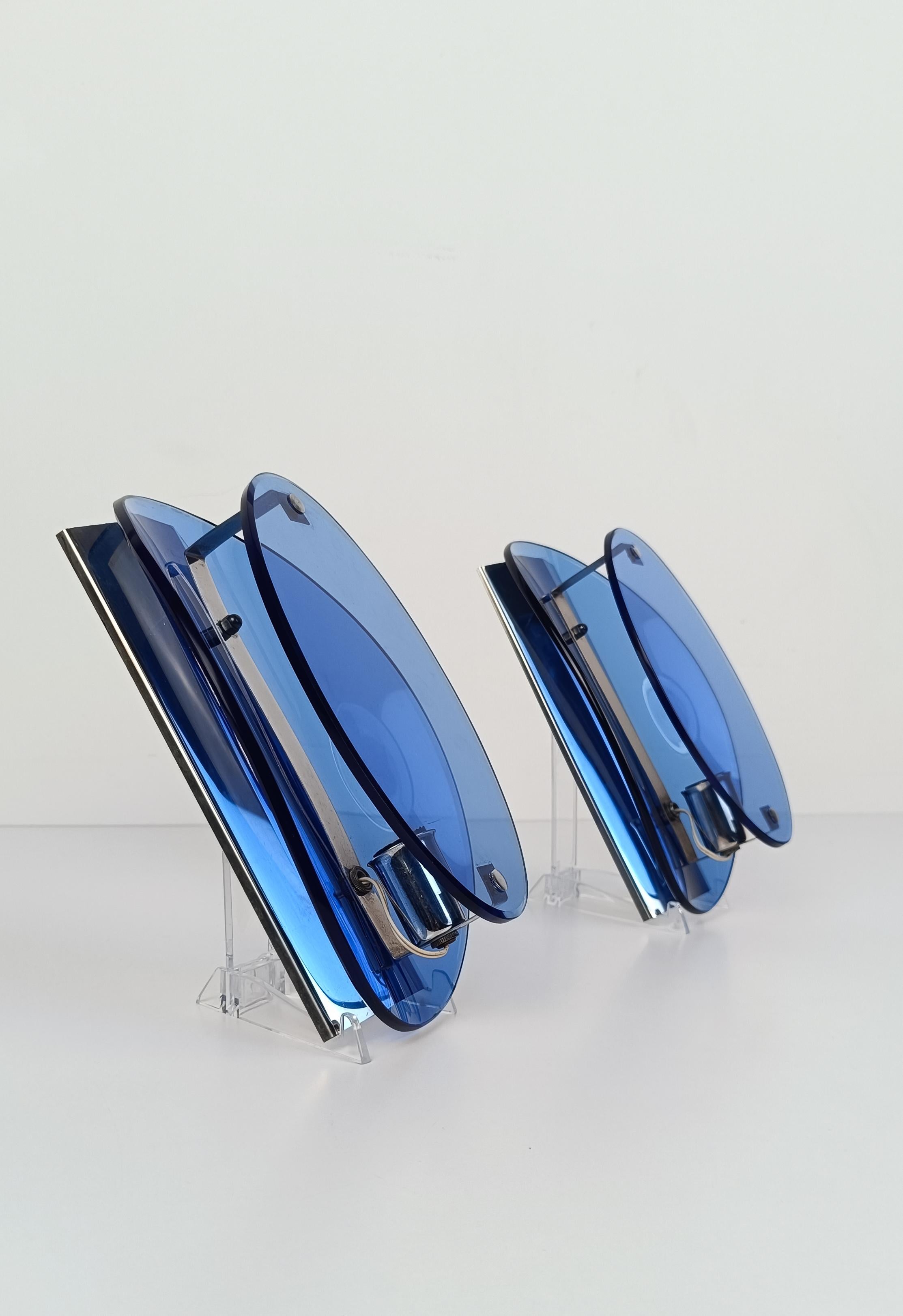 we offer for sale a pair of wall lamps that fully express the elegance of mid-20th century Italian design.
on an essential chromed metal structure with a light are housed two ultramarine blue glasses, on two different levels, which color and shield