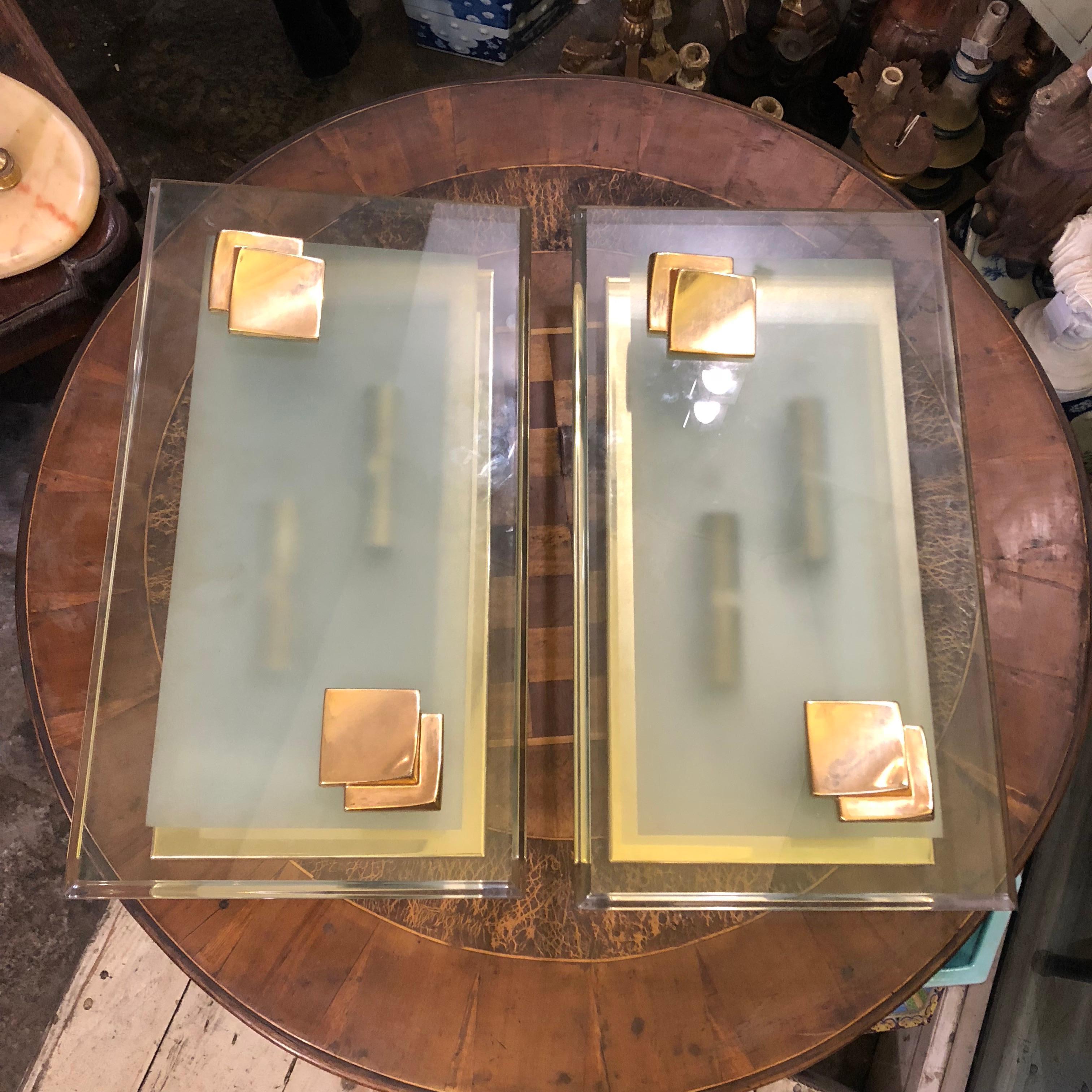 A pair of huge 4 lights wall sconces made in Italy in the 1960s in perfect conditions. they are in heavy verde nilo glass and brass. They works with 110-240 volts and need 4 regular e14 bulbs. The original patina create a vibrant vintage look.