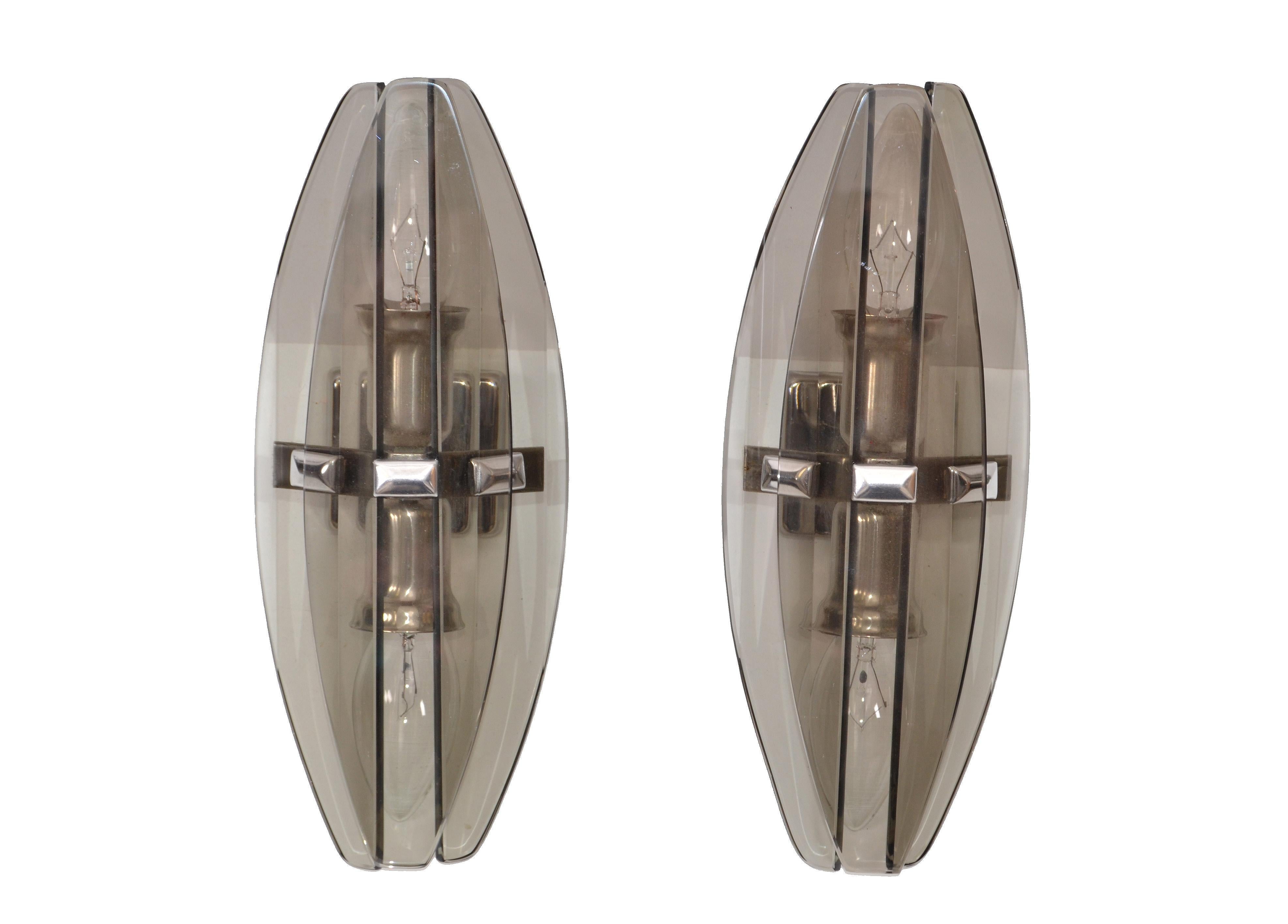 Italian Mid-Century Modern superb pair of smoked glass blades wall sconces styled after Fontana Arte.
Each sconce takes 2 candelabra light bulbs with max. 40 watts.
In perfect working condition.
Back plate measures: 2.25 x 1.5 inches.