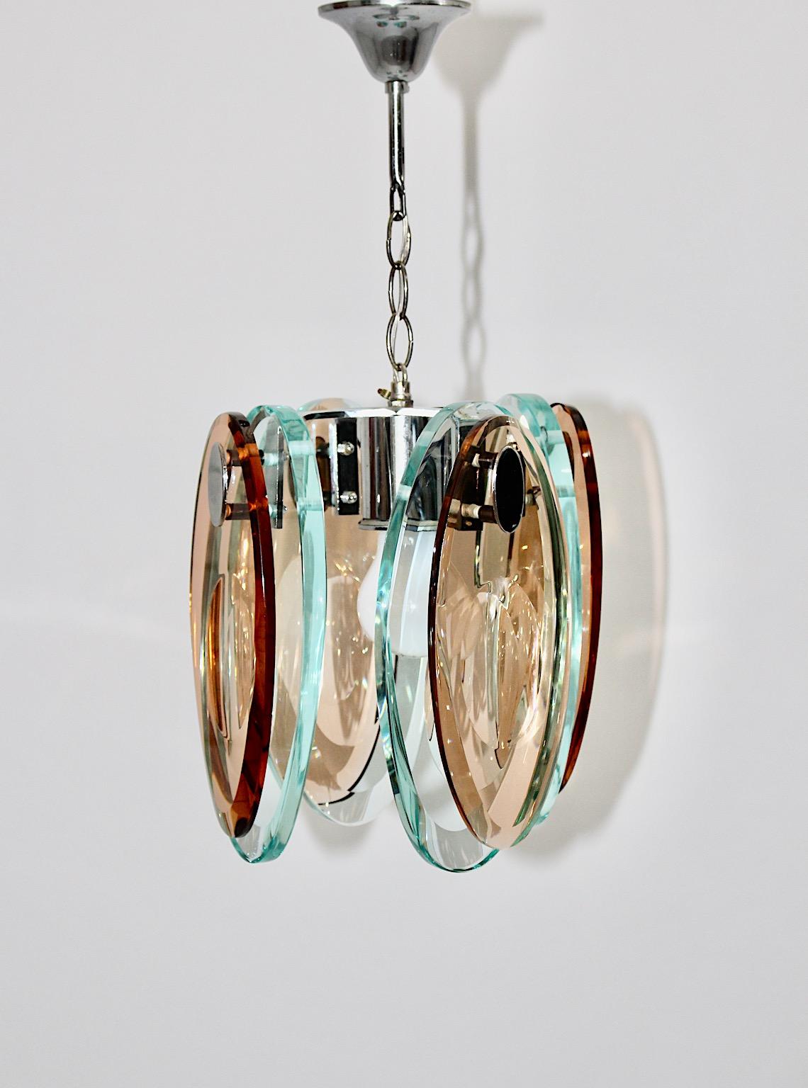 Modern vintage chandelier or pendant Fontana Arte style in blue teal and brown thick glass sheets and chromed metal 1970s Italy.
An amazing glass chandelier or pendant from polished elliptical like thick glass sheets in stunning blue and brown with